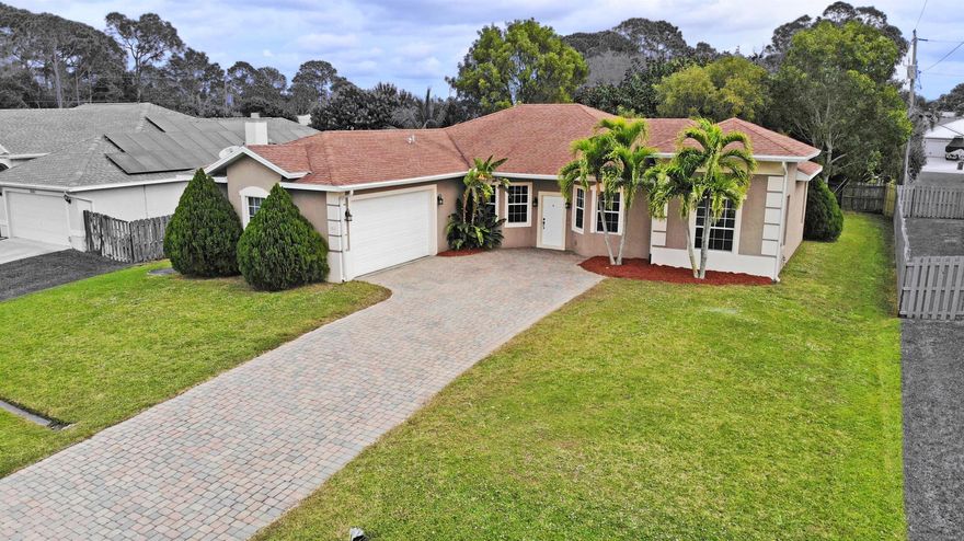 This exquisite 3-bedroom + den, 2-bathroom CBS home boasts elegance and functionality. Leading up to the house is a lengthy paver drive with plenty of room. Offering a spacious 2-car garage with high garage door, tile flooring throughout, and luxurious granite countertops. Tall ceilings and 8 foot doors throughout enhance the open ambiance, while the split bedroom layout offers privacy and comfort. Enjoy the serene screened-in patio with high ceilings that extends almost the length of the entire house with several sliding doors leading out, perfect for relaxing or entertaining guests - also with a separate sliding door from the master bedroom and a cabana bath when needed. Freshly painted interior. City utilies. Easy access to I-95 for commuters and also a few minute drive to the turnpike