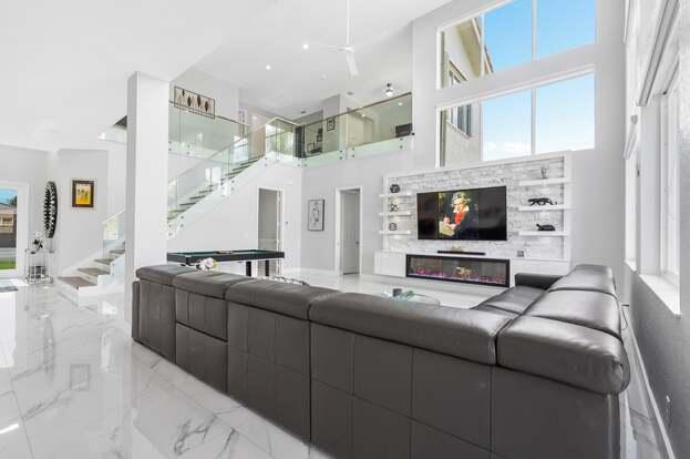 This stunning 5-bedroom, 4-bath lakefront home has been transformed with high-end upgrades, sleek finishes, and smart features throughout. From the brand-new roof to the impact windows and doors, every detail has been carefully curated for comfort, safety, and style.Enjoy motion-lit stairs, EV charger readiness, a new garage door, and a spacious backyard perfect for entertaining. Inside, you'll find soaring ceilings, a modern kitchen with a new dishwasher, and the cool comfort of a brand-new AC system.Whether you're hosting lakeside gatherings or enjoying quiet evenings at home, this move-in-ready gem delivers luxury, location, and lifestyle.