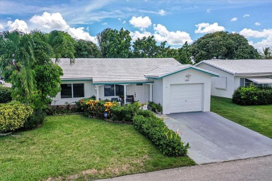 Fall in love the moment you pull up to this charming 2-bedroom, 2-bath corner lot gem in a vibrant 55+ community! This isn’t just a house—it’s your next happy place! Step into a remodeled designer kitchen with stainless steel appliances. The spacious family room can easily be used as a third bedroom, office, or media room—your choice! Enjoy bright bedrooms, Upgraded bathrooms, and a laundry room with a washer and dryer. The new floors and loads of natural light make this home shine. New AC. Impact windows and impact garage door. The exterior is equally impressive- beautifully manicured landscaping, an inviting front porch, and fruit trees that add a tropical touch. This home offers the lifestyle you deserve. Low HOA. Don’t wait—schedule your showing today before it's gone!
