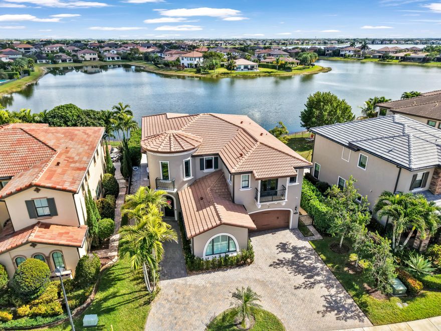 Welcome to your dream home, featuring exquisite upgrades and stunning views. This remarkable property offers the best view on the lake, enhanced by new panels in the expansive windows and sliding glass door that brings in natural light. The circular driveway ensures ample parking and easy access. The home includes a generator hookup with a transfer switch for added convenience. Enjoy privacy with hedges on both sides, creating a tranquil oasis. Inside, elegant wood flooring on the second floor adds warmth. The inviting pool, complete with a hot tub, is perfect for relaxation and entertaining. Built-out closets provide generous storage. This home combines luxury, functionality, and beauty! Don't miss the chance to make it yours!
