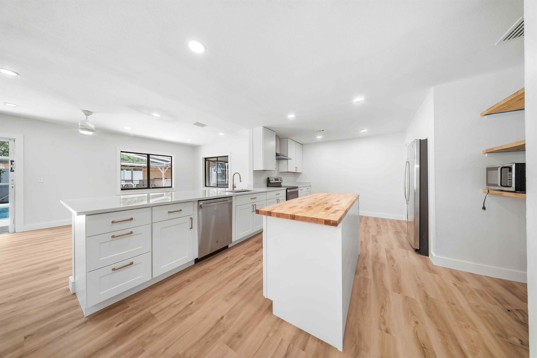 Welcome to this beautifully renovated 3-bedroom, 2-bathroom home that is perfectly positioned on an oversized corner lot in a quiet neighborhood. Step inside to find luxury vinyl flooring throughout, modern appliances, and a stylish kitchen featuring quartz countertops and a butcher block island--perfect for entertaining. The updated, natural stone fireplace adds warmth and charm to the spacious living area. Both bathrooms have been completely remodeled with spacious double vanities and contemporary finishes. Outside, enjoy your fully fenced private backyard complete with an in ground pool, relaxing hot tub, and outdoor kitchen area, ideal for Florida living and year-round gatherings. Don't miss this opportunity to rent or own this piece of property. *pool photos are not updated yet.