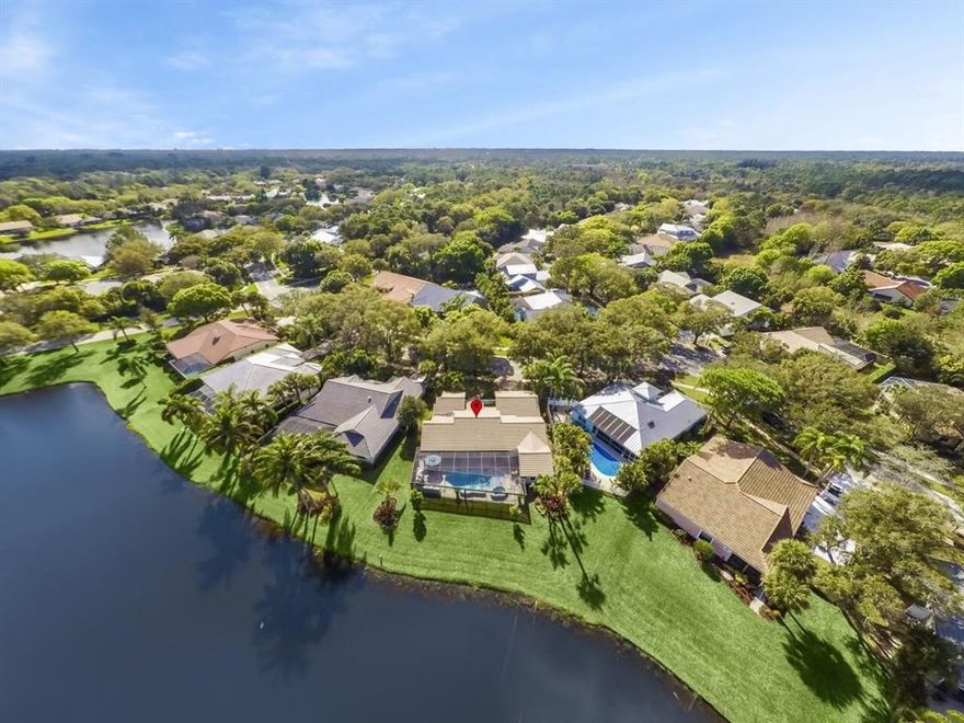 Welcome home to your own backyard paradise in the desirable community of the Shores of Jupiter! Enjoy cool Florida evenings with family and friends by your heated saltwater pool while serving homemade pizza from your own pizza oven. The custom outdoor area features waterfall hottub, travertine tiles, an amazing outdoor kitchen, sunshelf, LED lighting in the pool and a ''picture window'' screened lanai with great views of the lake. This well-appointed 4 bedroom home features a modern renovated kitchen with an abundance of cabinet space and gorgeous waterfall quartzite counters, stainless appliances and a wine fridge. Beautiful Brazilian hardwood floors are featured in the living areas with wood look tile floors in the bedrooms. Enjoy beautiful views of pool and lake from almost every room. Double doors lead to owner's suite that includes a rain shower, walk in closet and French doors leading to the backyard.  Additional features include, impact windows, custom pull down shades on all windows, high hat lighting, Whirlpool washer and dryer, new ceiling fans, new closet doors, epoxy floors in the garage, custom wood shelving, pull down stairs for storage, and pegboard for tools in garage.  Roof was replaced in 2005, water heater (2017), instant hot (2018), a/c (2015) with ultraviolet light, lush landscaping with custom curb stones all around the yard, pavered driveway and courtyard.  Some furniture is negotiable.  Close to shopping, I95 and turnpike, restaurants, beach and excellent schools.