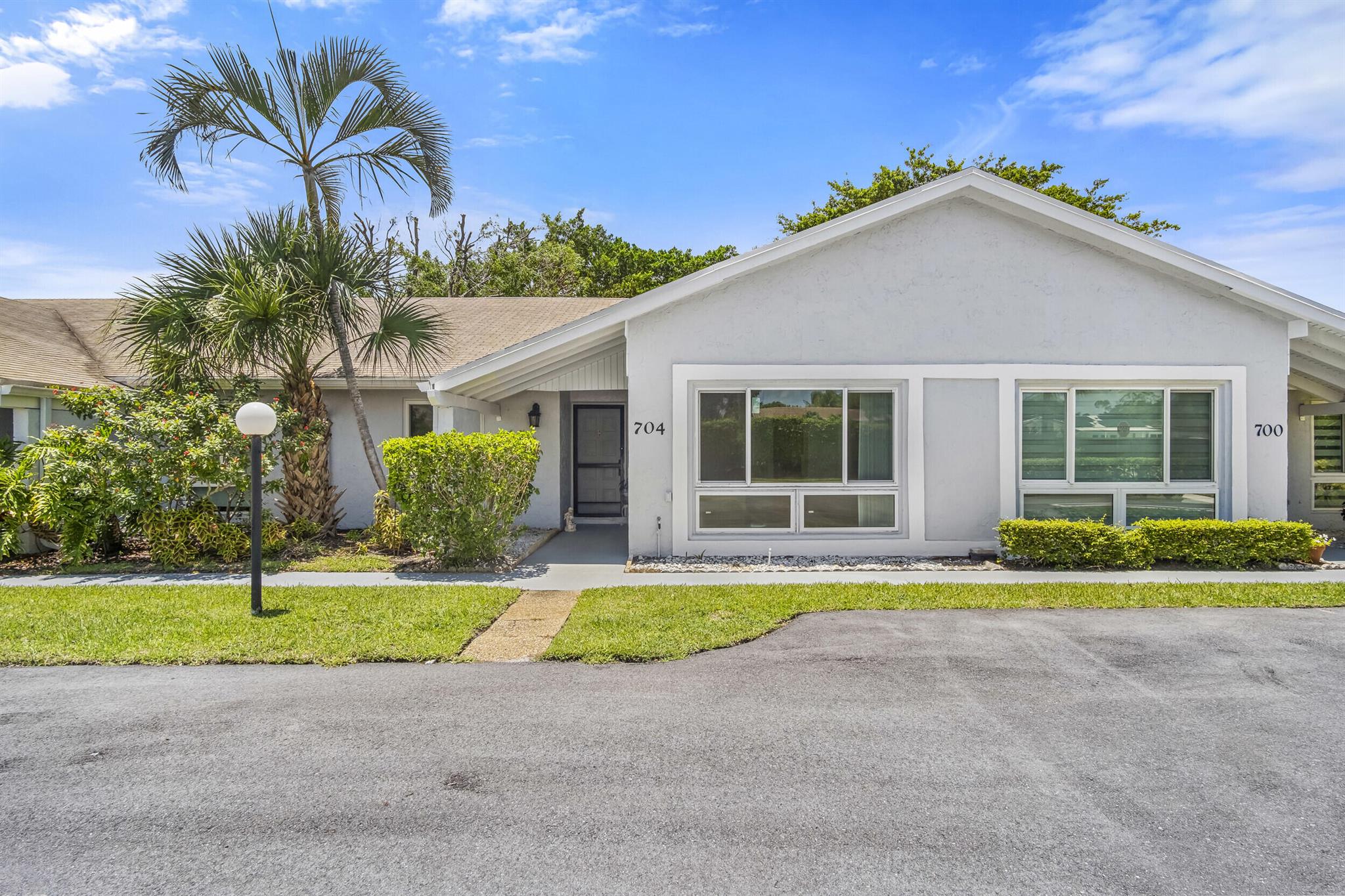 Great ''All Ages'' 2 bed 2 bath villa with 1440 sqft under air and 2 front door assigned parking spots. Includes high vaulted ceilings making it bright and airy plus tile floors throughout. You'll appreciate the split floor plan with large bedrooms, ample storage, full size W/D, great room, off kitchen dining room and breakfast nuke, and large screened patio! It's in close proximity to the pool, clubhouse, tennis, and guest parking lot. HOA cares for the roof which was replaced in 2018. Investor friendly since you can rent right away. Great Location! Between Atlantic Av and Linton Blvd, across from Delray Beach Golf Course, near to highways, minutes from FAU and downtown Delray with tons of restaurants, sopping and entertainment, and just a few miles from the beach. Come take a look!