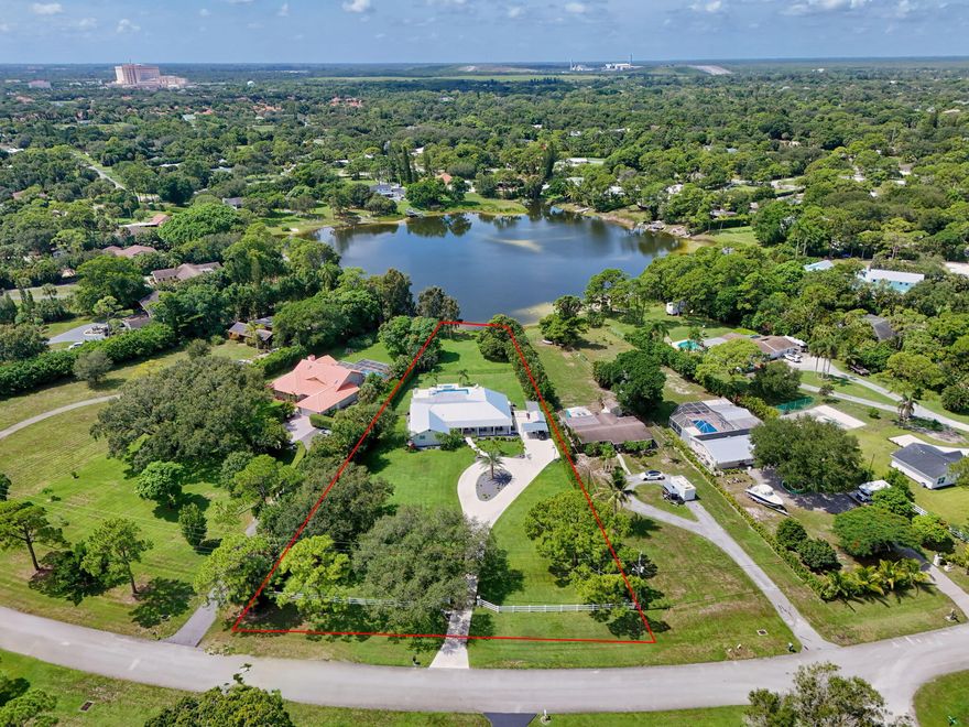 Rare Lakefront Estate on 1.3+ Acres - Fully Remodeled, No HOA! Seize this extraordinary opportunity to own a stunning 5-bedroom + office, lakefront home on a sprawling 1.3+ acre lot, free from HOA restrictions. This meticulously remodeled CBS-constructed residence blends luxury and functionality with top-of-the-line features. Enjoy peace of mind with impact glass windows, a new metal roof, and a secure front entry gate. The gourmet kitchen is a culinary masterpiece, boasting high-end appliances, custom cabinetry and oversized Island. The home's open-concept design showcases vaulted ceilings, creating an airy and grand atmosphere. Relax in the state-of-the-art movie theater w/ full Sports Bar or unwind by the brand-new 17x34 pool and Hot tub, complete with a fully equipped summer kitchen