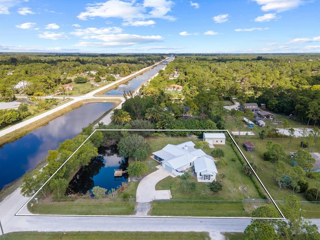 WELCOME TO THIS BEAUTIFUL OASIS THAT SITS ON AN OVERSIZED 1.63 ACRE CORNER LOT!! THIS HOME HAS SO MUCH TO OFFER. LETS START WITH THE BRAND NEW METAL ROOF, 2 PRIMARY SUITES PLUS A HUGE EAT IN KITCHEN, AND DOUBLE SIDED FIREPLACE FOR BOTH LIVING ROOM AND DEN.THIS IS THE PERFECT PROPERTY FOR MULTI-FAMILY LIVING OR FOR A HUGE FAMILY. ALSO FEATURES A 24X36 INSULATED STORAGE SHED THAT CAN BE USED FOR AN OFFICE OR WORK SHOP. 2-CAR ATTACHED GARAGE BRING YOUR BOAT, R/V etc. THIS IS CLOSE TO THE WELLINGTON EQUESTRAIN AREA. THIS PROPERTY HAS MATURE TROPICAL FRUIT TREES. THE ATTACHED GUEST HOUSE WHICH OFFERS: A SEPARATE FRONT COVERED ENTRY W/SINGLE DOOR ENTRY INTO A GREATROOM WITH BAY WINDOW AND A FULL KITCHEN,2-FULL BATHS AND MOTHER-IN-LAW SUITE. THIS IS A MUST SEE!!