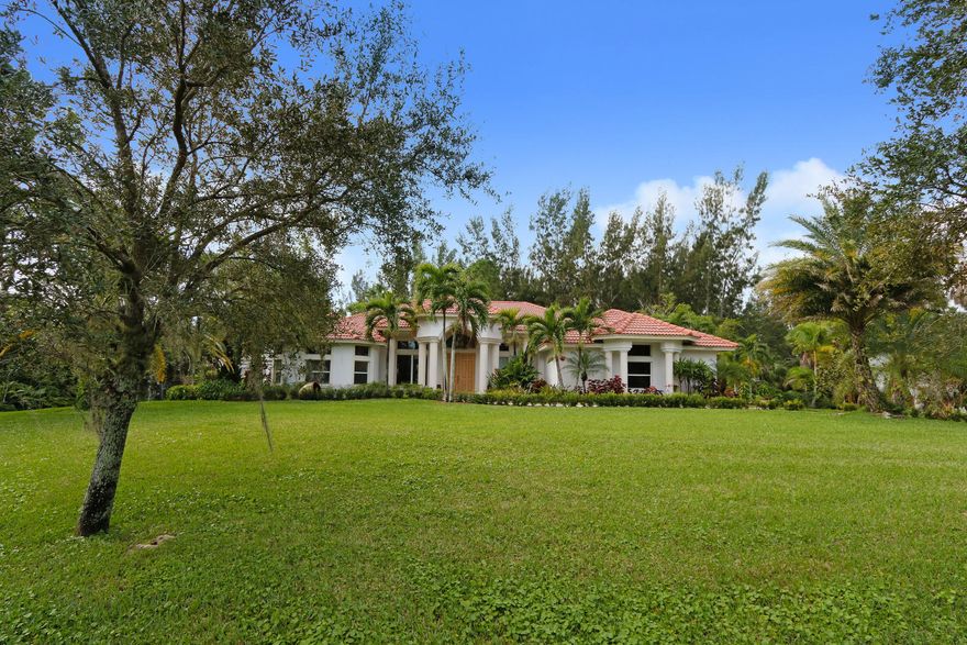 Quality built home on a beautifully landscaped 2.16 acre lot. Plantings include Canary Island Date Palms, Mango and Cocoa trees, rare Bamboo, Macadonia Nut and many others. Circular tumbled brick driveway. Recently remodeled Chef's gourmet kitchen features mahogany and marble counter tops, Miele burner range, Bosche dishwasher and subzero built in refrigerator. Grey, Black & natural wood cabinetry. The entire home has 24'' travertine top grade, diagonal marble. On suite bedroom offers an 18ft double shower, separate water closet with bidet, double vanity and tub. Front entrance features marble floor and custom designed hand wrought chandelier. Total home generator. Pool has built in pet safety ledge and sheet water fall. Many more extras to mention.