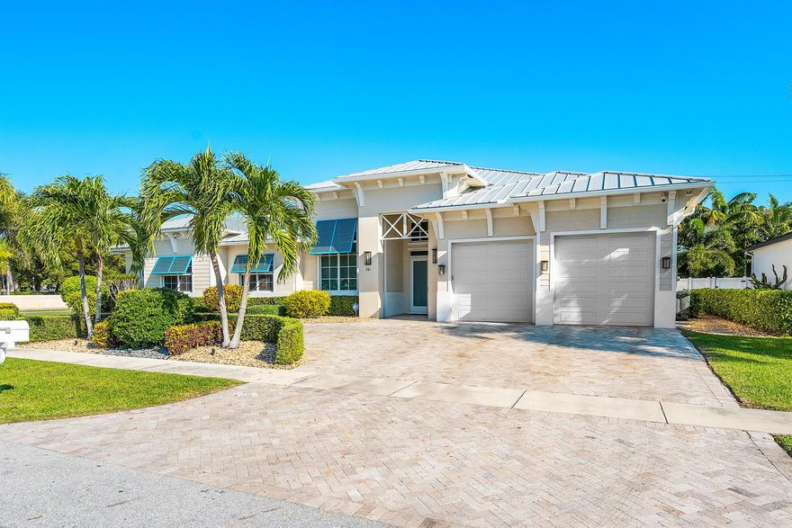 Rarely available single-story estate located on a corner lot just one block from Mizner Park! A coastal style home with modern features, volume ceilings, expansive glass and so much more! The updated kitchen features gas cooking, three ovens, two sinks, beverage center and one of the largest islands in East Boca. The adjacent bar is perfect for entertaining, within the stunning great room overlooking pool. The patio features a large covered area, overlooking saltwater pool, surrounded by shell stone pavers, with a large grassed area, perfect for dogs and playsets. Back inside, you'll find the primary suite with two large closets, spa bath, and separate sitting room soaked in light. A VIP suite is perfect for special guests, while two additional