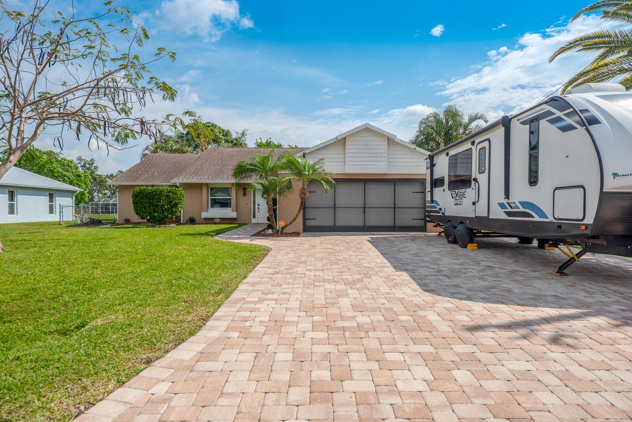 This 3-bedroom, 2-bathroom home with a 2-car garage offers stunning lake views and a prime location near top schools and beaches. Enjoy high ceilings, brand-new luxury vinyl plank flooring in the bedrooms, and hurricane-impact windows. The eat-in kitchen features stainless steel appliances, elegant cabinetry, and recessed lighting. The spacious primary suite boasts patio access and custom blinds, while the fully fenced backyard is perfect for entertaining with lush landscaping, fruit trees, a shed, and room for a pool. Relax on the large screened-in patio with tongue & groove ceilings. With a newer roof, AC, and paver driveway, this move-in-ready home won't last long--schedule your showing today!