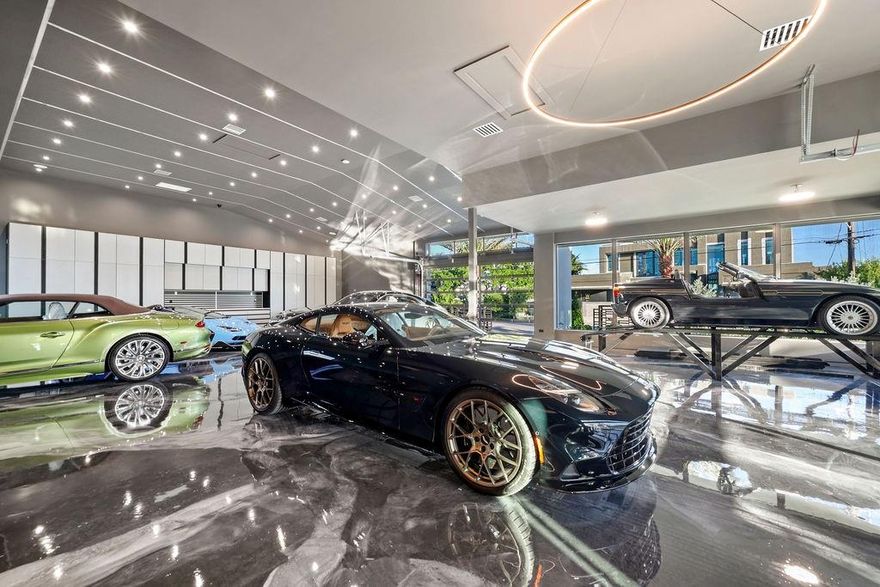 20-Car Garage in unmatched luxury at this new waterfront estate spanning nearly 13,000 sq. ft. Designed for the ultimate lifestyle, it offers a 3,500 sq. ft. showroom garage with space for 20 cars, a state-of-the-art gym, and the option for a private movie theater, or all of the above. With 6 bedrooms and 6.2 baths, the residence features a lavish primary suite, gourmet chef’s kitchen, and a media & club room with a pub-style wet bar. High-volume ceilings, sleek modern design, and floor-to-ceiling windows showcase stunning lagoon views throughout. Outdoor living is redefined with a resort-style pool, summer kitchen, and tranquil water features. A 78’ deep-water concrete dock accommodates large yachts, all just minutes from the ocean, beaches, and airport.