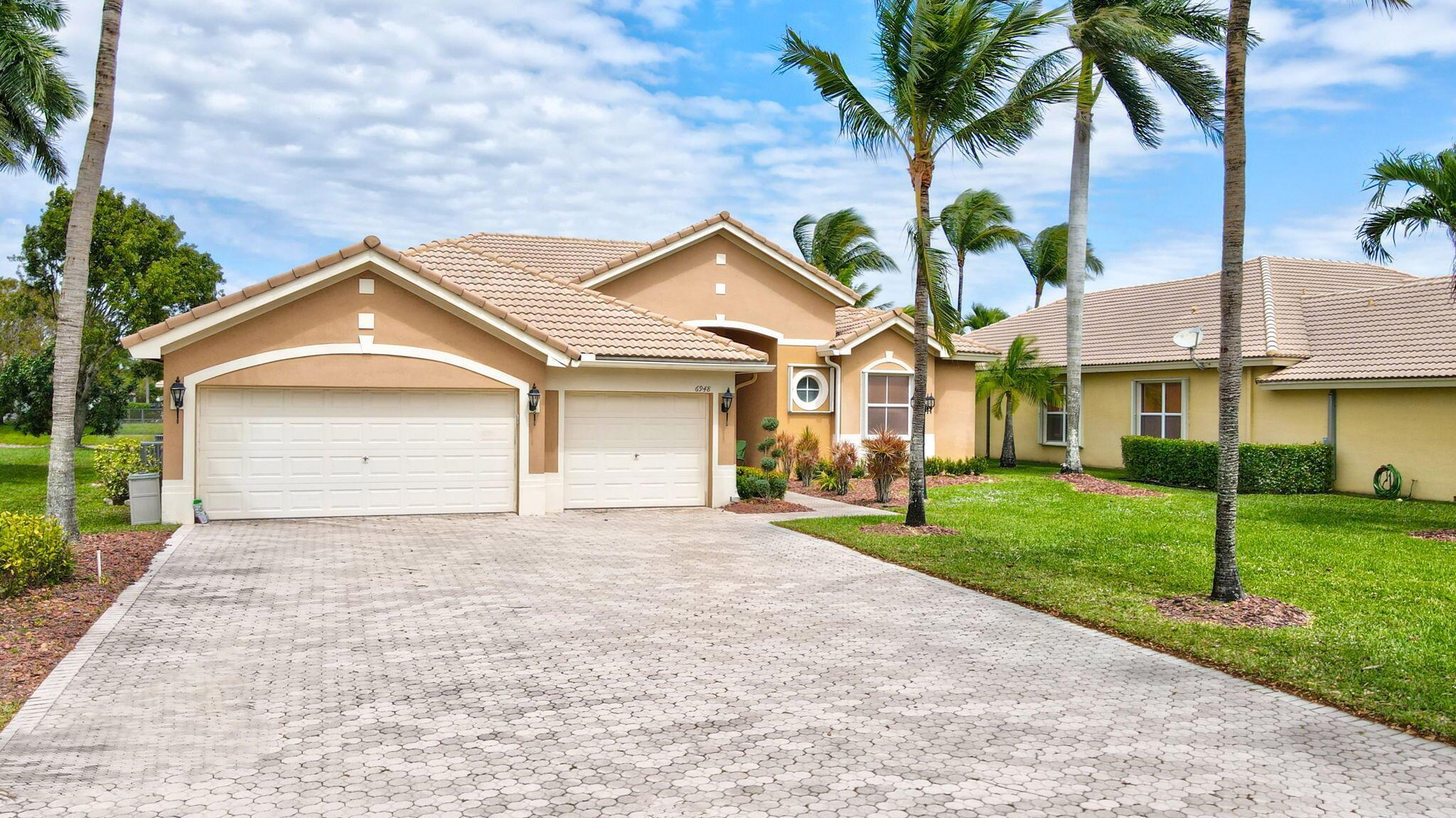Located in the prestigious estate section of Parkland Isles, this waterfront home offers curb appeal and stunning views. The home features tray, volume ceilings, crown molding, recessed lighting, and neutral tile throughout main living areas. The gourmet kitchen is equipped w/granite countertops, elegant cabinetry, breakfast bar, and ample storage space. A desirable 3-way split bedroom floor plan ensures privacy, with the primary suite showcasing custom closets, a sitting area, and serene water views. The spacious primary bath includes a double vanity, whirlpool tub, and separate shower. Accordion shutters, impact doors, and a fenced pool area complete the home. Photos have been virtually staged, and the property presents a wonderful opportunity to add your personal touch.