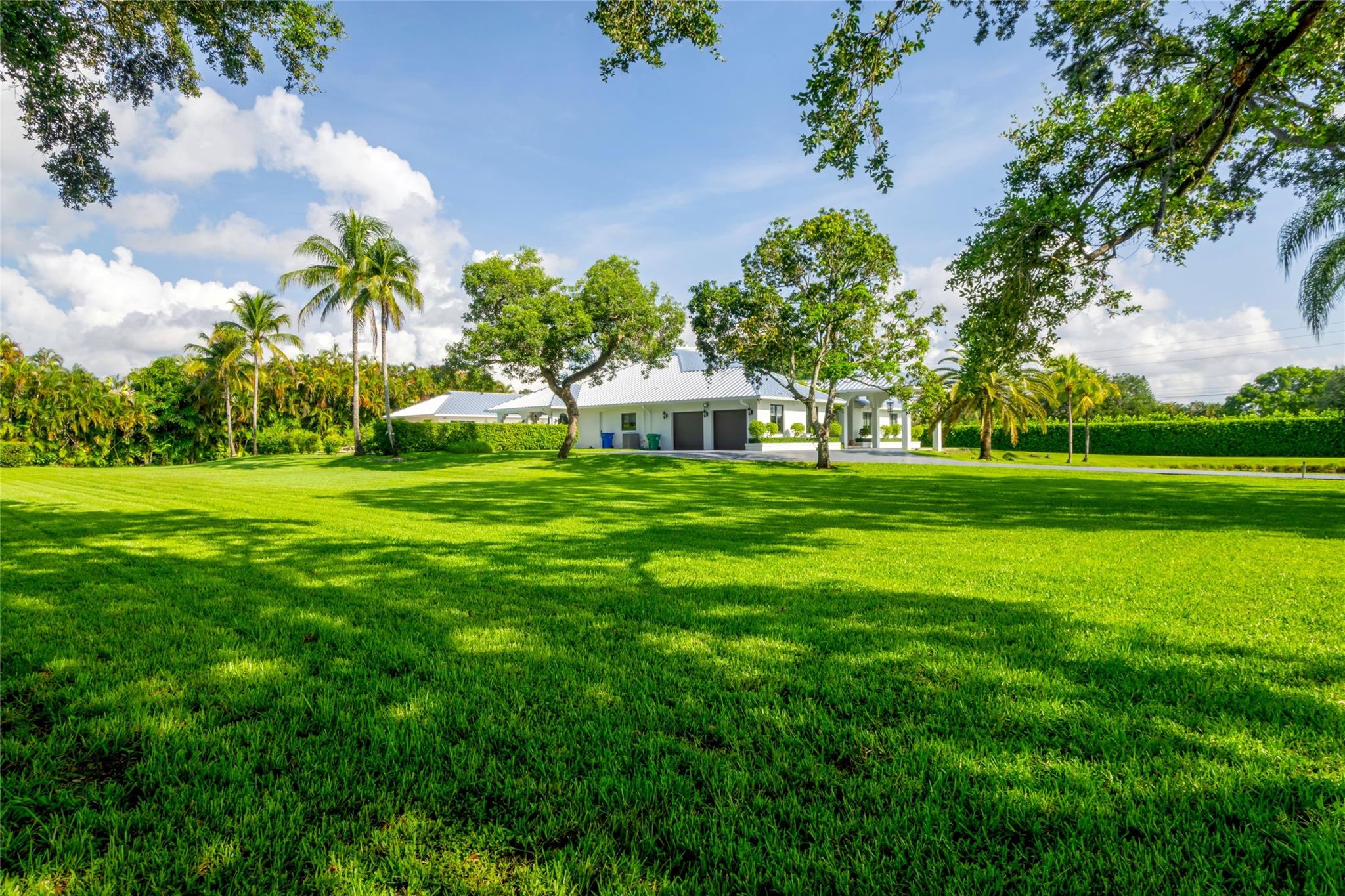 Sited on nearly 2-acres in the Estate Section, this 8,084± total sq ft residence with guest house offers the ultimate rural retreat. Updated with a sophisticated modern European aesthetic, this 4-Bedroom residence & separate 2-bedroom guest house, complete with a full kitchen, living & laundry, is perfect for hosting visiting family/guests. Luxe chef's kitchen, with adjoining pool-view breakfast room, has work island & dining extension, finished with exotic zebra-wood cabinetry & professional-grade appliances. The master suite offers pool-courtyard access, a spa-like quartz bathroom with jetted tub, double vanities, walk-in shower, separate steam room & water closet. Privately hedged & gated this estate appeals to equestrians, nature enthusiasts, and VIP's seeking privacy. 2024 Metal Roof
