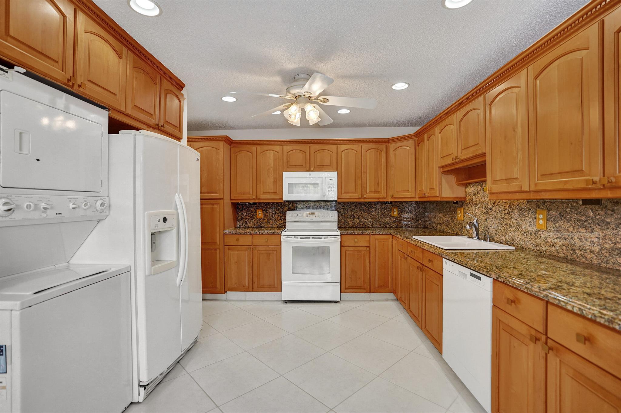 This beautifully maintained waterfront condo offers 1,335 sq. ft. of living space. Spectacular western sunset views over the lake from the oversized lanai, while the eastern kitchen window fills your mornings with sunshine.Inside, you'll find an expansive eat-in kitchen granite countertops and full granite backsplash, real wood cabinets, pull-out shelves, under-mount lighting, a large pantry, and a built-in desk. The thoughtful floor plan offers 8 closets in total, including a large lanai closet for extra storage. Updated bathrooms, accordion shutters, and a new roof installed in 2022With a retractable front screen door and lanai sliders, you'll love the natural cross-breeze throughout the home. An elevator conveniently brings you to the second floor, making access easy.