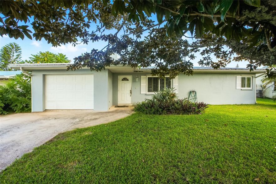 Charming 2-bed, 1-bath home with a 1-car garage in central Port St. Lucie. Features a bright living area with mirrored accents, tile flooring throughout, and an updated kitchen with white cabinetry and granite countertops. Enjoy the spacious screened patio overlooking a large, private backyard with lush landscaping. Convenient to shopping, dining, and beaches. Tenant occupied on a month-to-month agreement, offering flexibility for investors or future homeowners. Move-in ready with great potential!