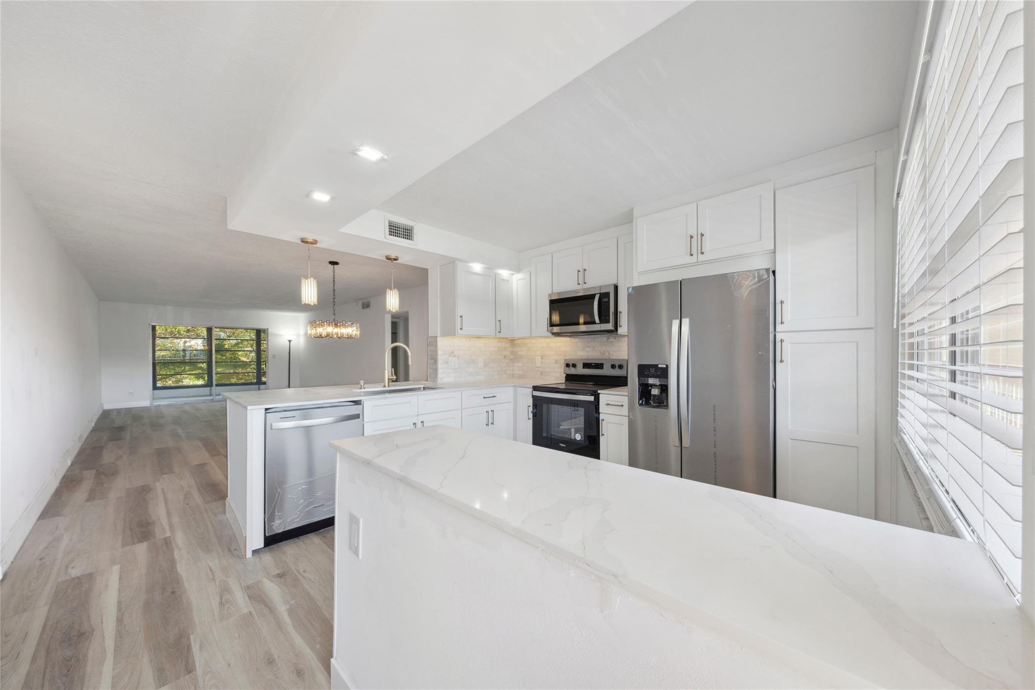 This is it! The most stunning unit in Wynmoor! Overlooking scenic golf course, this spacious 2/2 has it all....renovated & redesigned from floor to ceiling! Outstanding features include remodeled, open kitchen w/ "New Strom Gold" Quartz countertops, solid wood cabinets w/ under cabinet LED lighting, marble backsplash & all-new stainless steel appliances; luxury vinyl plank flooring throughout; entirely & gorgeously renovated bathrooms, including redesigned master w expanded, frameless shower & stone-floor finish, all new pluming, fixtures & vanities; brand new A/C & water heater; all new electrical panel & new wiring to all-upgraded fixtures, & more! Enjoy the amenities and lifestyle of Wynmoor, and the peace of mind of a fully renovated unit and building w/ completed 40-year inspections!