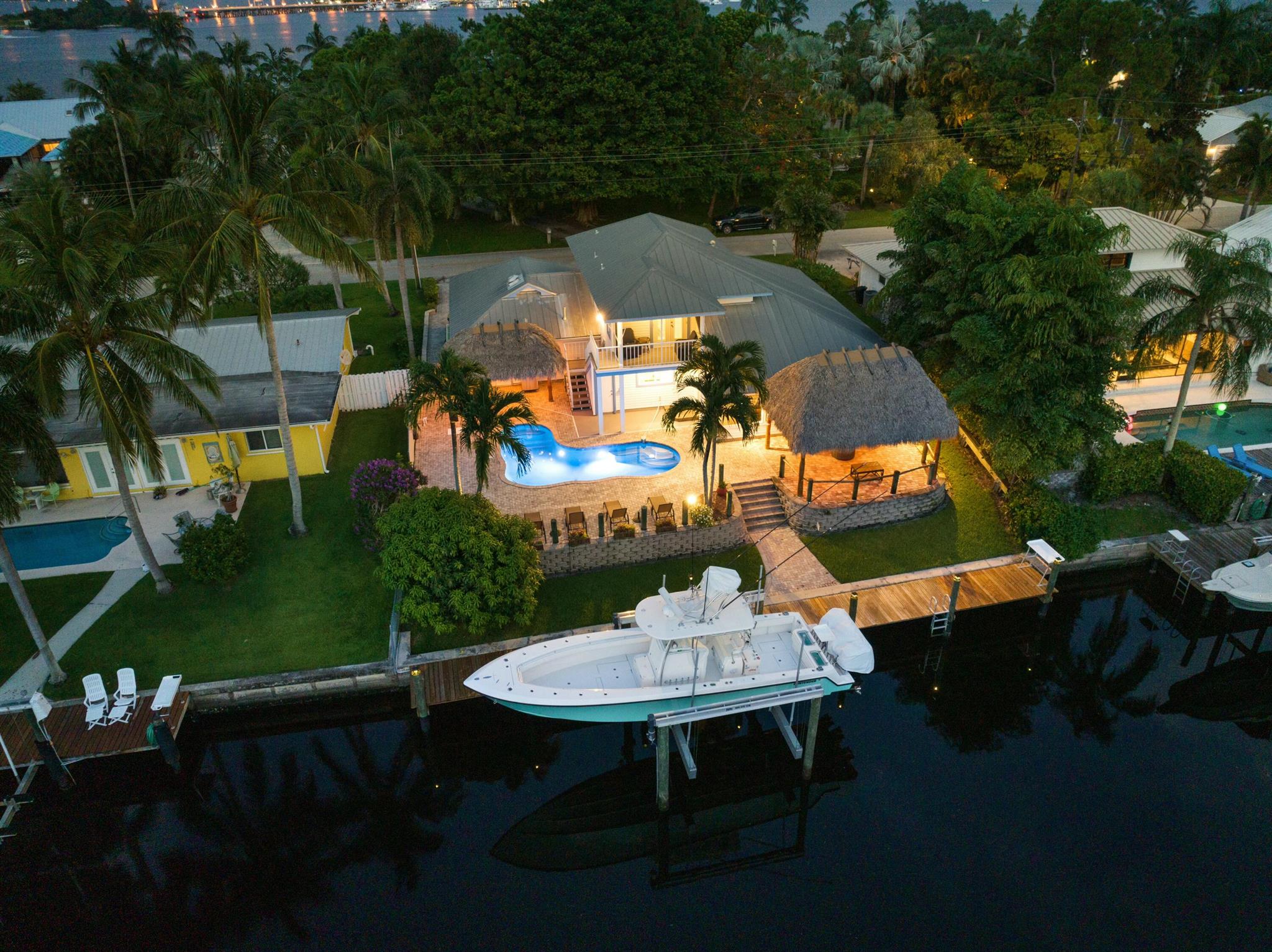 Your waterfront paradise awaits in the sought after waterfront community of Lighthouse point. Jump into a saltwater heated pool after a long day fishing. This is an entertainers dream with 2 tiki huts, LED lit pool and landscape lighting. A new 20,000 lb boat lift and top of the line kitchen. Upon entering the high vaulted ceiling and solid wood double helix staircase brining you to the primary suite. The master bath is large with his and her vanity, large walk in shower and closet. Kitchen offers Sub-Zero Fridge, Capital 6 burner gas range and a full butler pantry/laundry room with full size freezer. IMPACT windows, plantation shutters and a fully finished garage. Florida lifestyle is only a backyard away, and this one will definitely impress.
