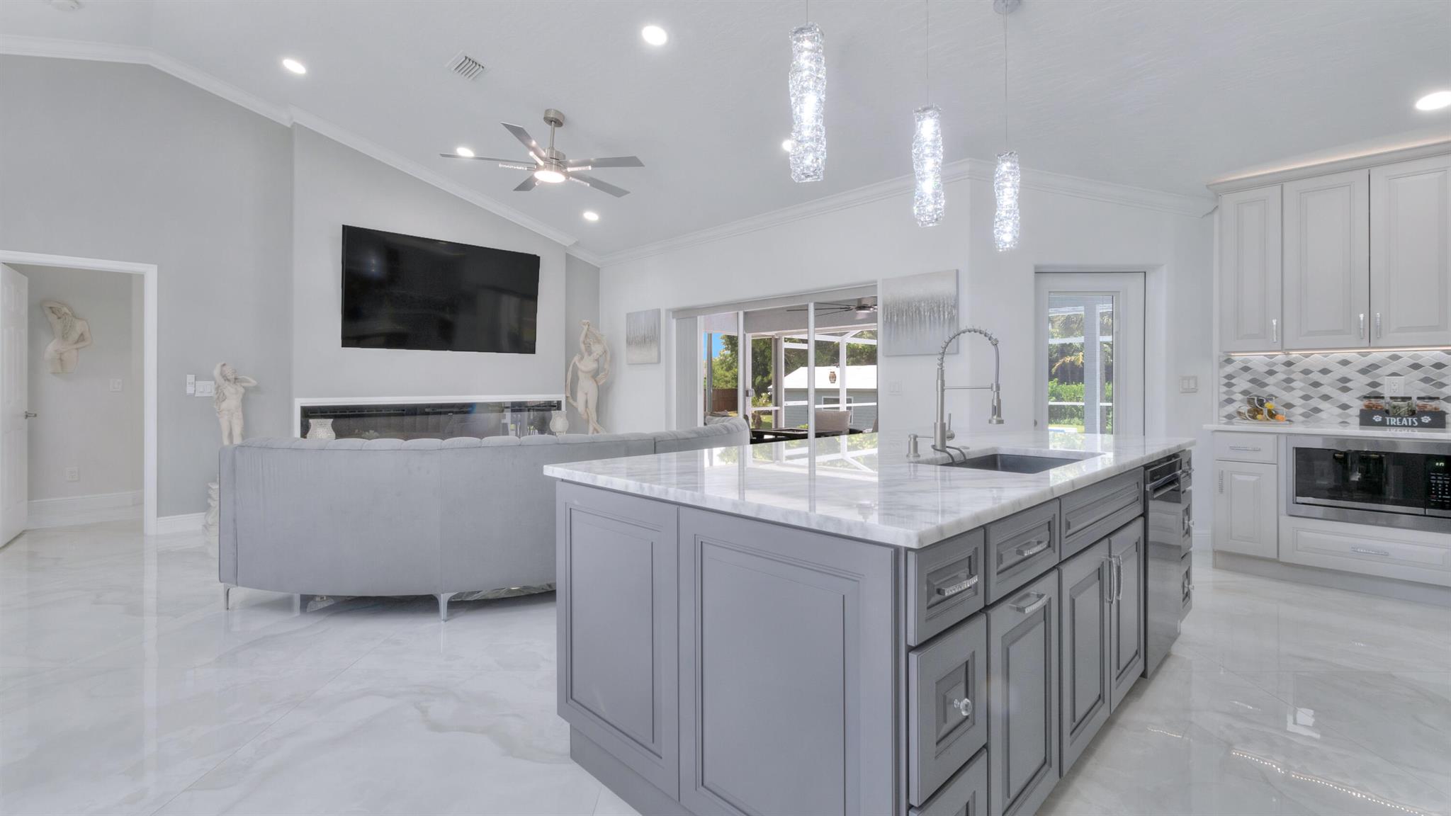 Step into a world of elegance and tranquility with this professionally decorated split-floor-plan home, masterfully remodeled with top-of-the-line materials and breathtaking attention to detail. Nestled at the end of a serene cul-de-sac, flanked by picturesque canals teeming with fish on two sides, this over half-acre property offers unmatched privacy and space with no HOA fees, giving you the freedom to personalize your lifestyle. As you enter, the open-concept layout welcomes you with crown molding, marble countertops, and exquisite finishes that elevate every inch of this home. The completely remodeled interior has new bathrooms, a state-of-the-art kitchen, and stunning flooring all crafted with the highest quality materials for a seamless blend of luxury and durability.