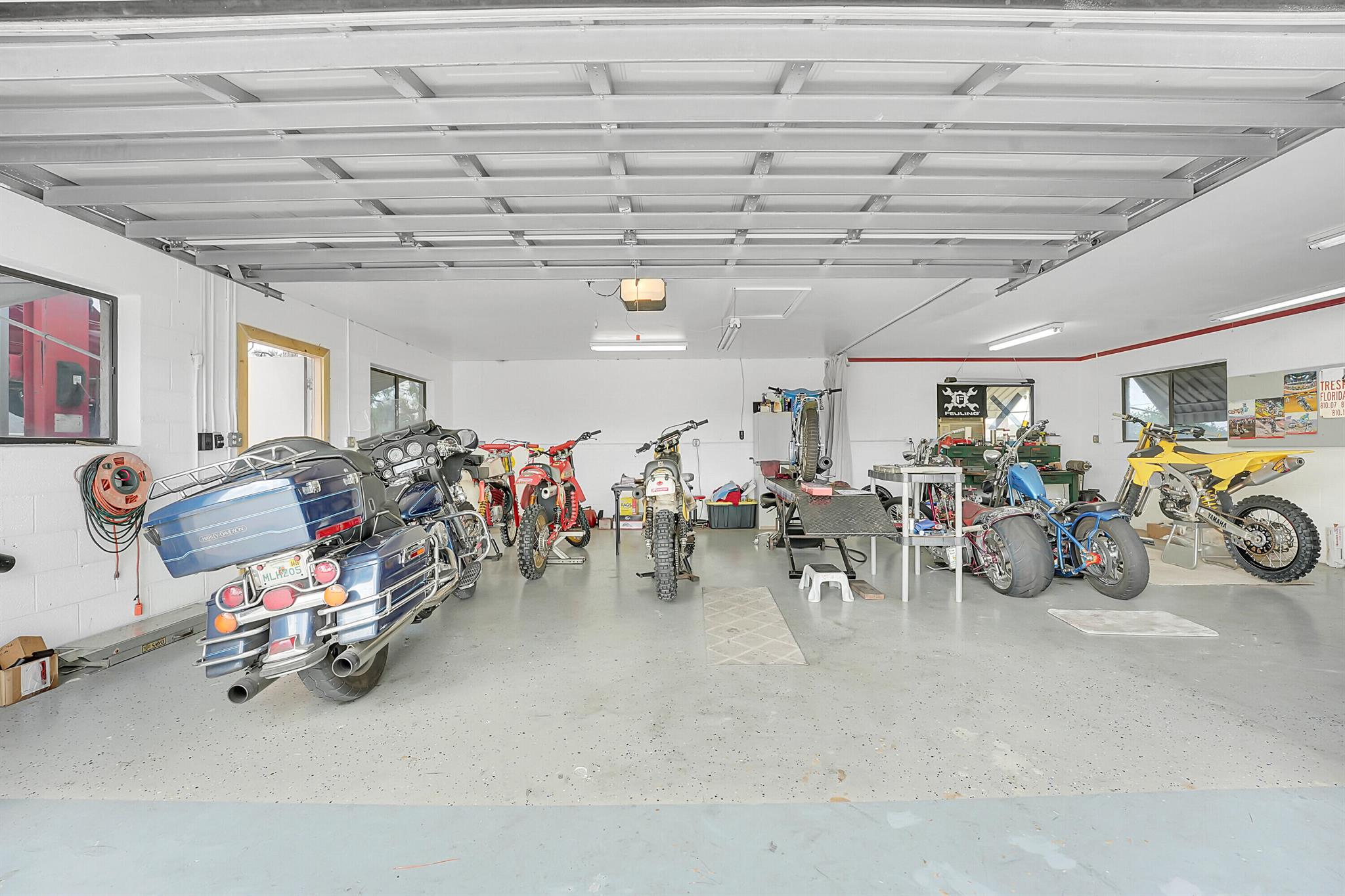 This property is ideal for car enthusiasts or DIY mechanics as it has a 24' x 12' carport with an 8,000 lb car lift. The detached 2-car garage is wired with 110 & 220, ready for serious work.This home sits at the quiet end of Bayshore on a rare double corner lot with no HOA, offering endless potential for business owners, hobbyists, or anyone needing space for vehicles, equipment or toys. Recent updates include a metal roof (2022), AC system (2020), and water heater (2021) - giving peace of mind for years to come. For storm protection, the home is outfitted with roll-down and accordion shutters, making hurricane prep quick and stress-free.Enjoy tile flooring throughout, new baseboards, granite countertops, stainless steel appliances, an eat-in kitchen & spacious dining room.