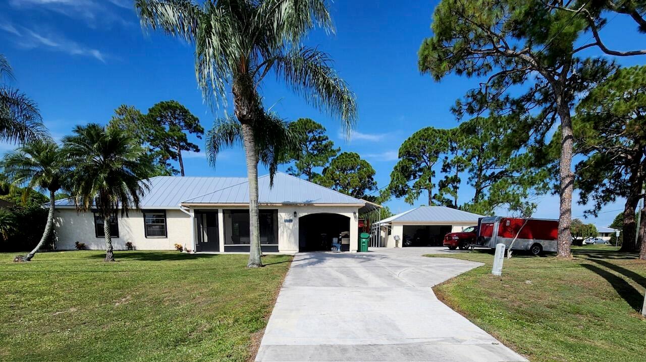 This property is ideal for car enthusiasts or DIY mechanics as it has a 24' x 12' carport with an 8,000 lb car lift. The detached 2-car garage is wired with 110 & 220, ready for serious work.This home sits at the quiet end of Bayshore on a rare double corner lot with no HOA, offering endless potential for business owners, hobbyists, or anyone needing space for vehicles, equipment or toys. Recent updates include a metal roof (2022), AC system (2020), and water heater (2021) - giving peace of mind for years to come. For storm protection, the home is outfitted with roll-down and accordion shutters, making hurricane prep quick and stress-free.Enjoy tile flooring throughout, new baseboards, granite countertops, stainless steel appliances, an eat-in kitchen & spacious dining room.