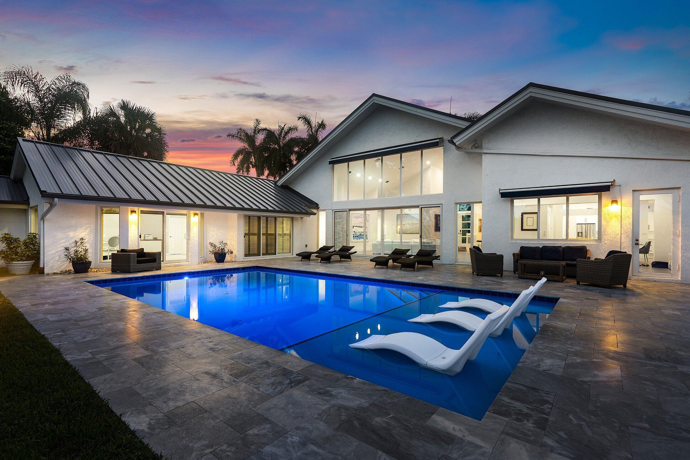 Step into modern elegance and timeless comfort with this beautifully renovated 4 bedroom PLUS OFFICE home, designed to impress at every turn. Sunlight pours through expansive IMPACT windows, filling the spacious open-concept living and dining areas with an inviting glow. The gourmet kitchen is a chef's dream, featuring high-end stainless steel appliances, sleek porcelain countertops, abundant storage space, and a large eating area. Your spacious master suite offers a serene retreat, complete with three walk-in closets, private sitting area and a spa-inspired bathroom. Three additional bedrooms plus a dedicated office provide comfort, versatility, and style for family or guests. Step outside to your private backyard oasis, where new resort-style pool with sun shelf awaits, surrounded by