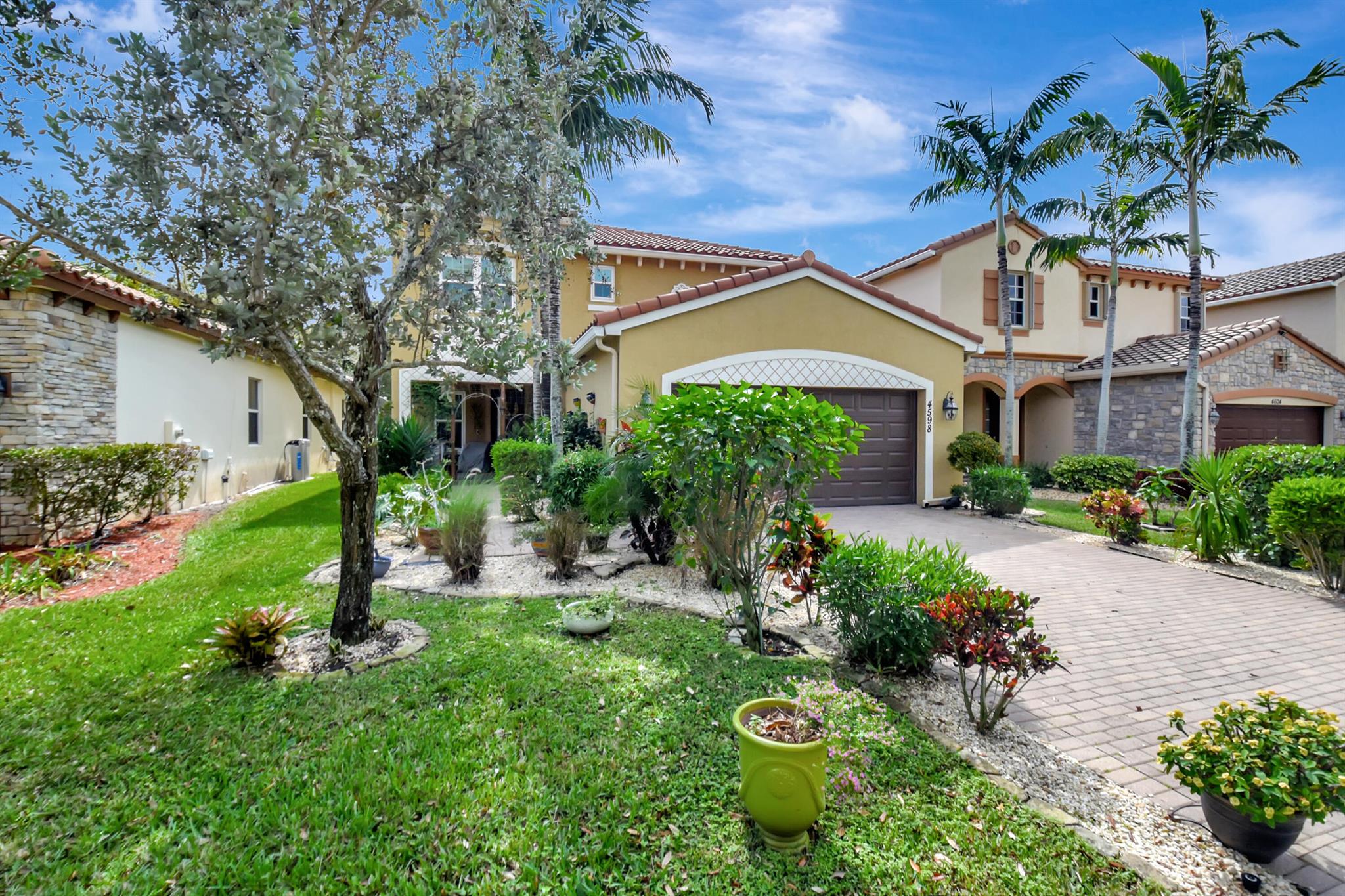 Welcome home to this stunning two-story residence in a gated community. This furnished 5-bedroom, 3-bathroom home with a 2-car garage is move-in ready and equipped with everything you need. The first floor features a formal living and dining room, a family room, and a kitchen with appliances. Additionally, there is a bedroom and a full bathroom on this level. Upstairs, you'll find a laundry room and four spacious bedrooms. The primary suite boasts two walk-in closets and an en-suite bathroom with dual sinks, a Roman tub, and a separate shower. The remaining three bedrooms share a full bathroom. Step outside to a tropical backyard paradise, complete with fruit trees, raised garden beds, wall-mounted planters, and a seamlessly integrated irrigation system perfect for aspiring gardeners