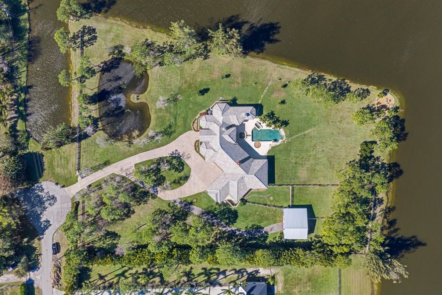 MULTI-USE, PRISTINE 5-ACRE POINT LOT surrounded by water, offering exceptional privacy and serene natural beauty. Gated entry opens to sweeping views, gentle breezes, and a peaceful setting with abundant wildlifeâ€”creating a true retreat-like atmosphere. Exceptional, sprawling ranch with high ceilings, large rooms, marble floors, large primary with sitting room and fireplace. Notable features include a whole-house generator, reverse-osmosis water treatment system, new ACs, new hot water heaters and a newly converted salt-chlorinated pool and spa positioned to take full advantage of the tranquil waterfront surroundings. Equestrian and animal enthusiasts will appreciate the newly built, multi-use barn with 4 stalls, electric, water, and partial A/C, suitable for private use or  CONTINUE income-producing boarding. Two dog kennels offer direct access to a separately fenced outdoor exercise area. Ideal for breeding dogs, goats, chickens, small livestock. The property includes three individual paddocks, each securely enclosed with chicken-wire-clad fencing, ideal for animal safety!  Perfect for equestrian pursuits, boutique breeding, hobby farming, or a private family compound.