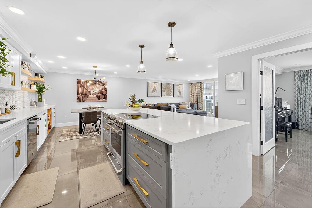 Introducing 5440 North Ocean, Unit 1404, Singer Island. This 2BR/2BA fully renovated waterfront condo delivers the strength, style, and location serious buyers look for. Built for performance and luxury, it features porcelain tile flooring, custom-built cabinetry, and quartz countertops with a bold waterfall edge finished in matte black and gold hardware.The chef-inspired kitchen showcases rich grey cabinetry, high end appliances, brushed gold finishes, a premium range with warming drawer, updated backsplash, a quartz slab with waterfall design, with an added wet bar adjacenta refined blend of form and function. The inunit washer/dryer adds everyday convenience.