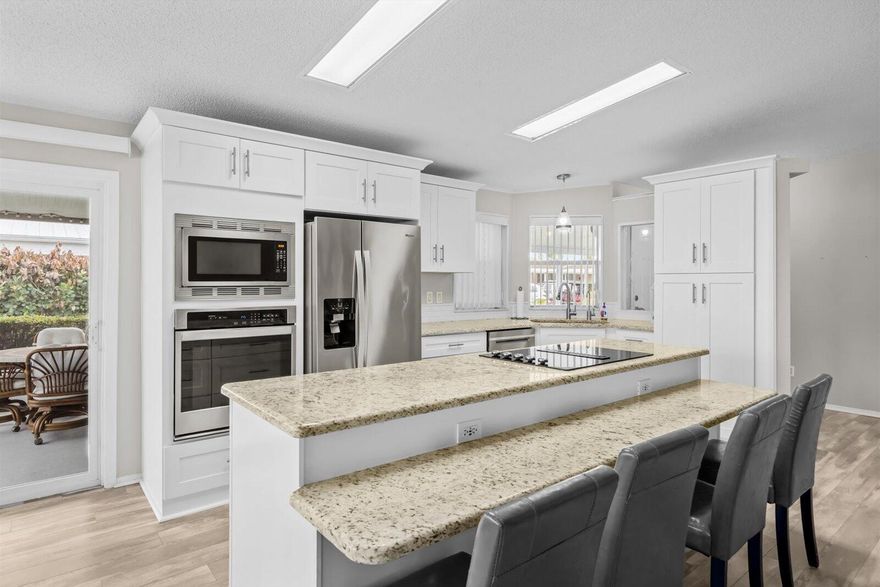 Welcome home to the ever-popular Islander III model, perfectly positioned for the Florida lifestyle you've been dreaming of! Imagine starting your mornings lakeside, enjoying peaceful water views right from your beautifully updated island kitchen featuring gorgeous granite countertops and an open, inviting floor plan. Home offers 2 BR's, 2 BA's plus a versatile den with elegant French doors--ideal as a home office, hobby room, or even a third bedroom for visiting guests. Update features include SS Appliances, 2019 roof, 2023 A/C, 2025 W & D, lam. floors thru/out. Located just a short golf cart ride to the 2 clubhouses, you'll enjoy access to 3 pools, a theatre, on-site restaurant, 18 hole golf course, recreation center, and endless activities in this vibrant 55+ community. Land Lease