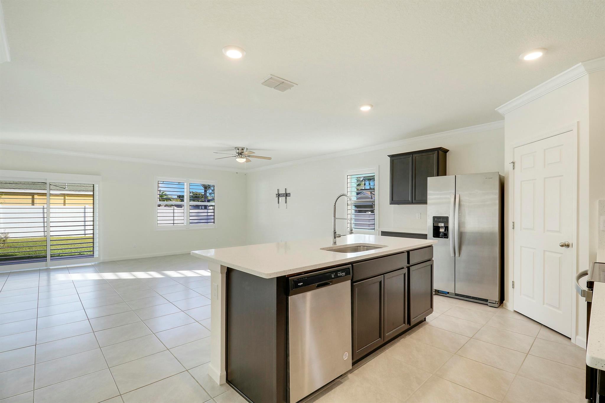 Beautifully upgraded 4-bedroom, 2-bath newer construction (2022) home featuring plantation shutters on all windows, quartz counters in the kitchen and bathrooms, tile throughout (no carpet), crown molding, and an epoxy garage floor. Located on a spacious corner, fully fenced lot close to Becker Rd with easy access to I-95 and the Turnpike. Close to Tradition, schools, and shopping.
