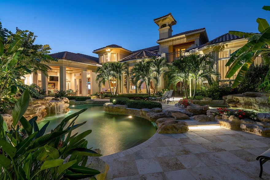 Immerse yourself in the unparalleled beauty of this exceptional waterfront estate, meticulously crafted in the prestigious Royal Palm Yacht & Country Club. With captivating waterway views, this bespoke residence offers a tropical oasis. Sprawling across an expansive 2.25 lots, encompassing over half an acre of lush greenery, and boasting an impressive 216 feet on the Buccaneer Palm Waterway, this architectural marvel designed by Randall Stofft promises an extraordinary living experience.Indulge in the enchanting ambiance of the meticulously landscaped grounds, where outdoor entertaining is elevated to an art form. Covered terraces invite you to savor the natural surroundings, while the multi-level pool and spa, thoughtfully positioned to embrace the southern exposure, provide the ultima