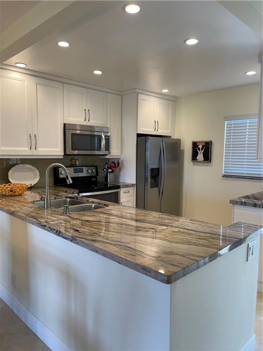 TAKING CASH  OFFERS.  SIMPLY GORGEOUS! EVERYTHING HAS BEEN REMODELED, all done with PERMITS.. Splendid open kitchen, 42-inch WHITE, shaker cabinets, granite counters, SS appliance package, LED high hats, no popcorn anywhere! Diagonal tile floors, IMPACT WINDOWS THROUGHOUT. barn style shower doors IN BATHS. Newer electrical panel, A/C, Water Heater, 4 ceiling fans, new glass front door, SECURED elevator with key FOB.  Only 3 miles to the beach. Patio is set up as Den.  Panel doors throughout with new baseboards. Pool view.  ACTIVE COMMUNITY: Bingo/bocci ball/billiards, ping pong, pickle ball, tennis, 2 pools, movies in RENOVATED club house. Minutes from 95 and LOW, LOW maintenance fee!!