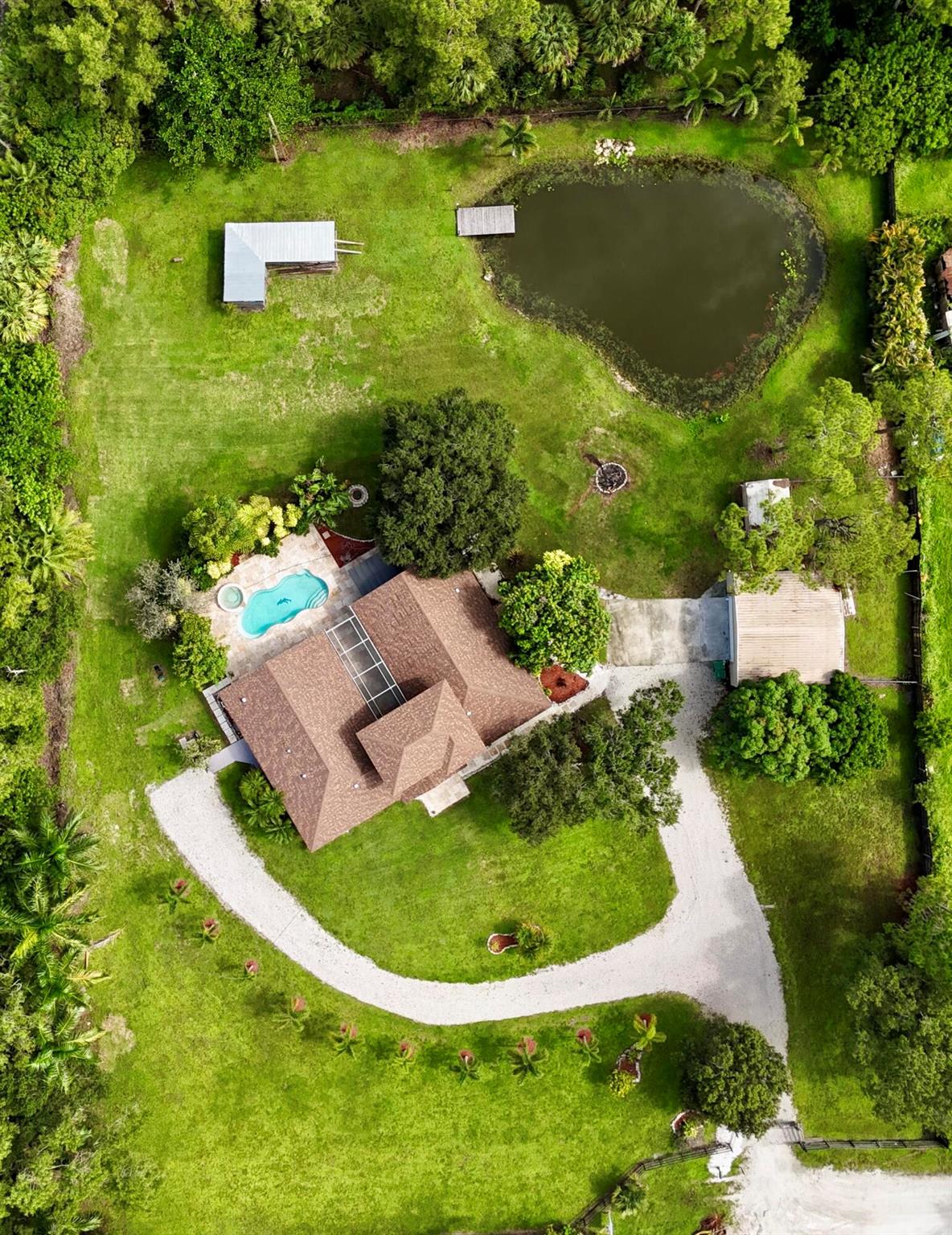 his stunning 4-bedroom home with a versatile 5th loft-style room offers endless possibilities, including the potential for a 5th bedroom. The spacious split floor plan provides ultimate privacy, with the main living areas centered around a screened-in porch, perfect for year-round enjoyment. The property features a serene pond with a dock, adding a tranquil touch to your outdoor living space. Enjoy the convenience of a separate garage, shed, and a small pole barn, all equipped with power for extra storage or hobbies. The entire yard is fenced and secured with an electric gate, ensuring privacy and peace of mind. This home truly offers a perfect blend of comfort, style, and functionality in a beautiful, secluded setting.