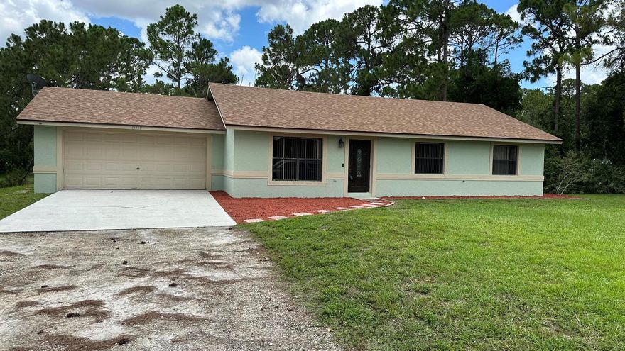 Three Bedroom, 2 bath 2 car garage, in the Acreage ready for it's new family.  Freshly painted.  New Roof, New Water System, Septic 2018.