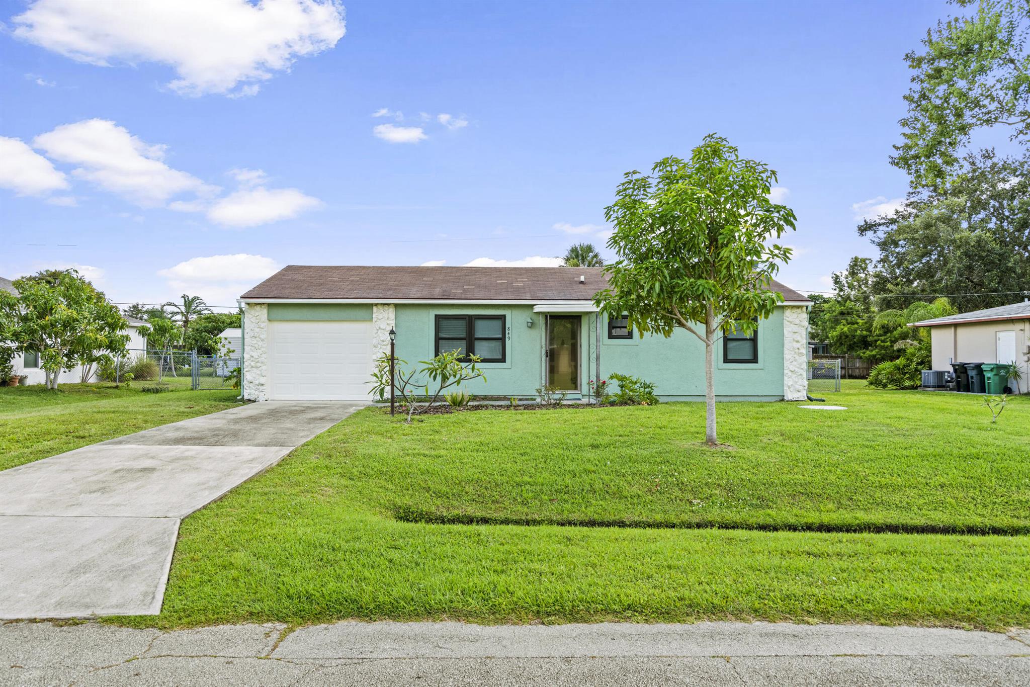 Move-in ready 2BR/2BA CBS home with garage on a quiet street. Freshly painted inside and out. Remodeled kitchen with quartz countertops, stainless steel refrigerator and range. New water heater (2021), newer garage door, and brand-new A/C (2024). Inside laundry with newer stackable washer/dryer. Tile throughout, including large enclosed porch. Impact windows with panel shutters. Fully fenced yard with shed, mango, papaya, and banana trees, plus a whole-house water treatment system. City water and sewer. Located off Floresta near Crosstown Parkway--5-minute walk to Coral Reef Park and the St. Lucie River. Approx. 20 minutes to the beach. Close to shopping, dining, schools, and healthcare.