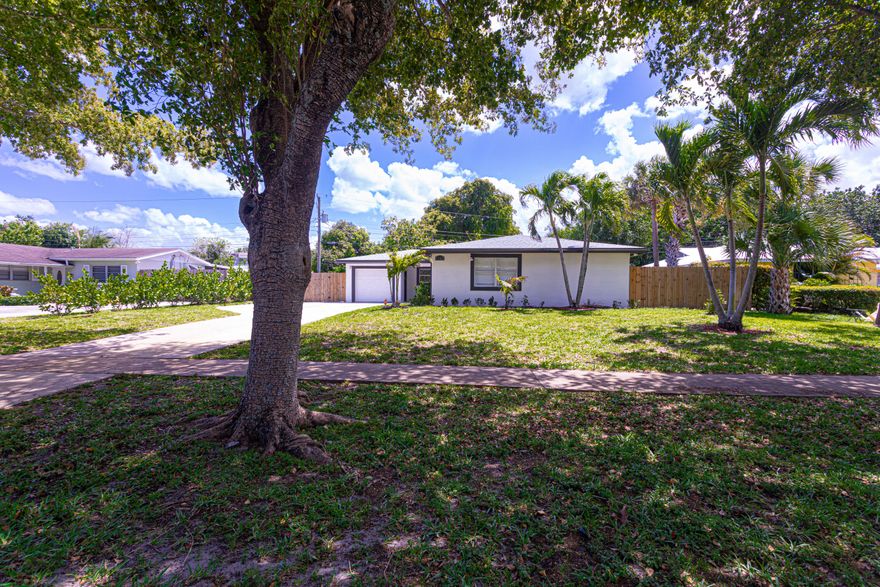 Fully Renovated Modern Oasis on over Half an Acre - No HOA! Experience the perfect blend of modern luxury and expansive outdoor living in this beautifully reimagined 4-bedroom, 2-bathroom home. Situated on a massive .54-acre lot that extends to Belvedere Rd, this property offers unparalleled freedom and space. The bright, open-concept interior features large-format porcelain tile, recessed LED lighting with custom dimmers, and brand-new French doors. The gourmet kitchen is a showstopper with sleek white cabinetry, striking dark stone countertops, and new stainless-steel appliances. Both bathrooms have been elegantly renovated with contemporary vanities and custom tile work.  Major upgrades provide total peace of mind, including a brand-new 2024 roof, a new septic system, and a newer high-efficiency A/C. Outside, the oversized paved driveway offers ample room for a boat, RV, and multiple cars, leading to an attached one-car garage. The sprawling backyard features a serene private pond and plenty of room for a pool or guest house. Located minutes from premium shopping, I-95, and the Turnpike with No HOA fees. This turnkey property is move-in ready!