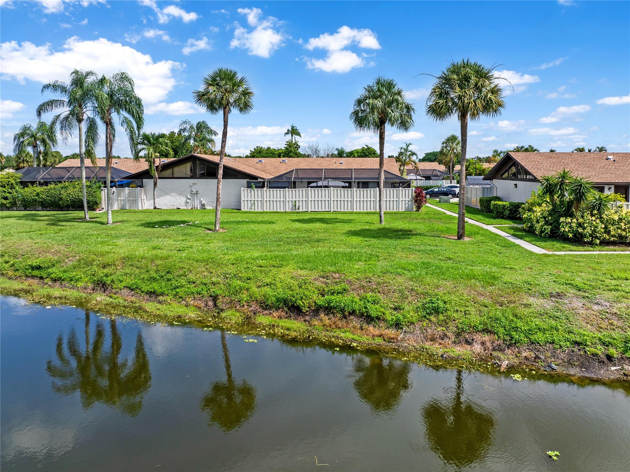This modern 3-bedroom, 2-bath home in the desirable Boca Gardens community. This beautifully updated home features vinyl flooring throughout, an open kitchen with extra-tall wood cabinetry, quartz countertops, and a spacious island—perfect for cooking and entertaining. Enjoy outdoor living on the large screened-in patio. The roof and patio screen were both replaced in 2023 for added peace of mind. The community offers resort-style amenities, including 3 swimming pools, tennis courts, a clubhouse, two assigned parking spaces, and guest parking.