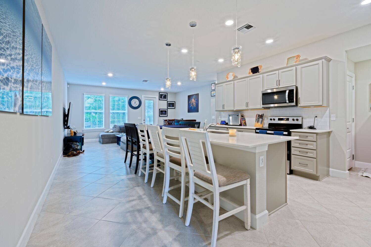 Welcome home to this stunning, coastal-inspired townhome located in the highly desirable Ocean Cove community. Newly built in 2022, this immaculate 3-bedroom, 2.5-bathroom residence effortlessly combines modern luxury with laid-back Florida charm. Step inside to discover an open-concept layout, illuminated by voluminous 9-foot ceilings and abundant natural light streaming through upgraded hurricane-impact windows and doors--ensuring both elegance and security.At the heart of the home is a gourmet kitchen, featuring a stylish quartz-topped island, spacious pantry, a dedicated coffee nook conveniently placed next to the refrigerator, and premium appliances including a Samsung smart refrigerator with SmartThings technology and two specialty ice options.