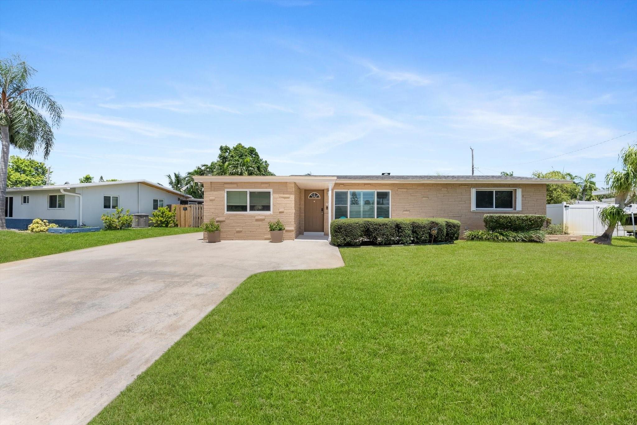 Brand-new roof! Perfectly updated & maintained! This beautiful home has an impressive curb appeal boasting an inviting front porch, oversized driveway, manicured landscape & a large front yard. The interior shines with plantation shutters, a beautiful kitchen with fine wood cabinetry, granite counters, & SS appliances. The spacious primary suite features a ensuite bath, large closet & wood-look tile floors. Out back, your private oasis awaits with a fenced yard, a full summer kitchen (refrigerator, grill, & sink), patio, gazebo, mosquito misting system, night lighting, & space for a pool, pets to roam, & kids to play. Bonus features include a sunny Florida room Impact windows/doors/some accordion shutters & roomy secondary bedrooms. RV, boat, trailer, etc. parking is allowed.