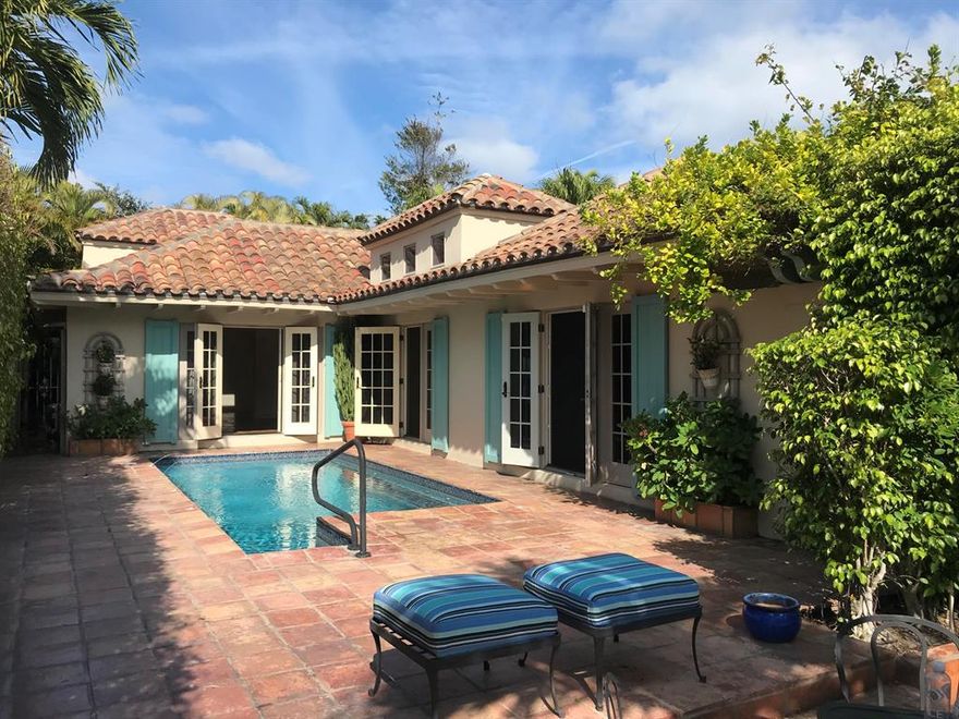 A lovely little gem in the heart of town with a country French soul to it that is topped with a handsome multi-hued barrel tile roof and terra cotta and brick patios, arbors all around. Le Ciel Bleu, The Blue Sky is a fitting name for this charming cottage featuring spacious rooms, most with French doors to a patio area or pool area. Three bedrooms and three baths, new kitchen, terra cotta floors, clerestory windows in the entry and library inviting in more blue sky. A surprise secret garden at the rear of the property is off the master bedroom. World class shopping, fine dining and the beach all within a block or two. Impact windows and doors and the beautiful terra cotta roof from 2004.