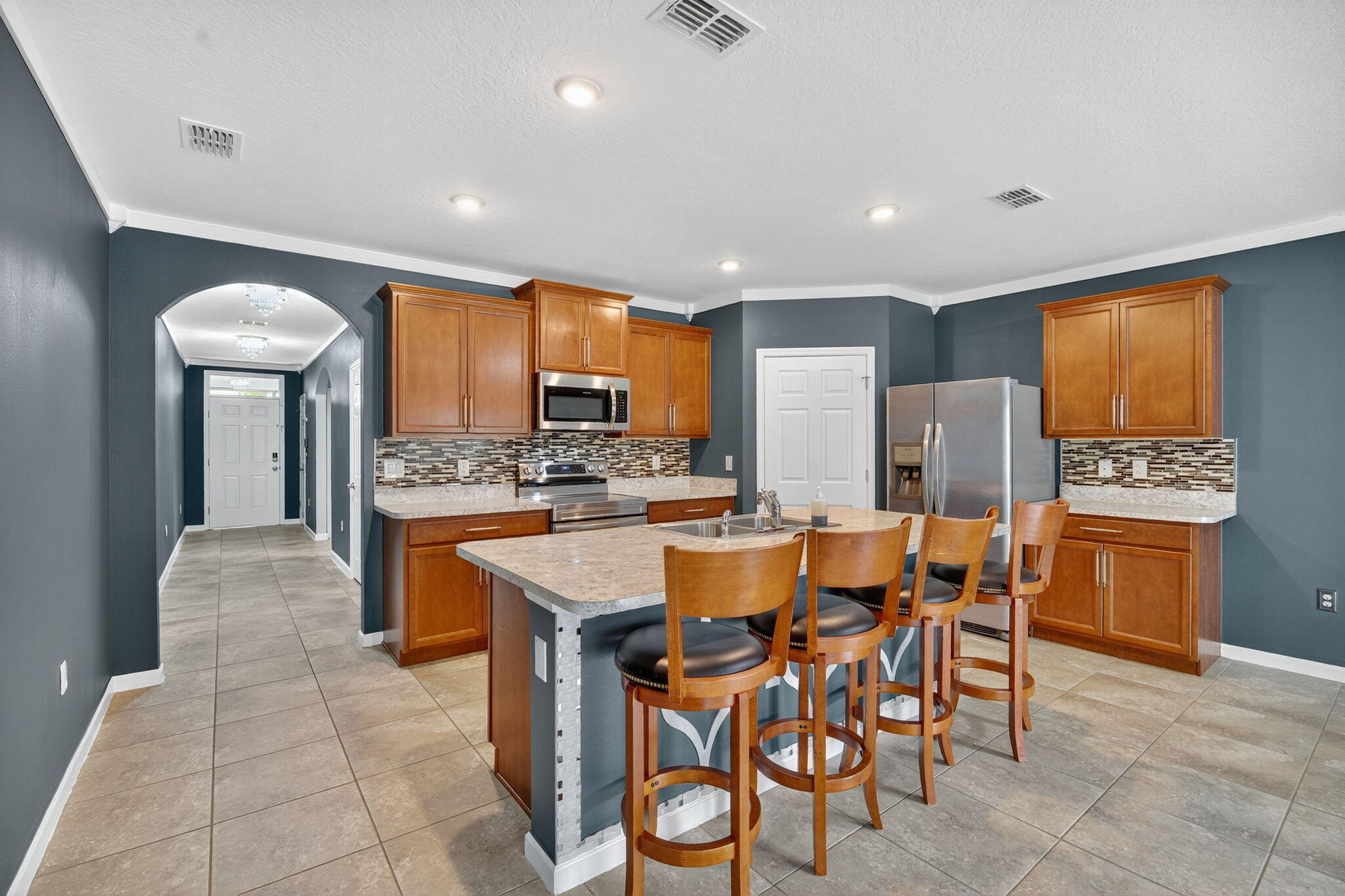 This stunning 4-bedroom, 2-bathroom home offers 1,846 sq. ft. of modern living with an open, light-filled floor plan. The stylish kitchen features stainless steel appliances, while the spacious primary suite boasts a walk-in closet and double vanity. Built in 2019, this home comes with custom molding and elegant finishes throughout. Flooring includes tile in the main living areas and laminate in the bedrooms for easy care and comfort. Step outside to a fenced backyard offering privacy and plenty of space to relax or entertain. Owner will pay for Lawn Care and Maintenance! Located in the desirable Port Malabar area, close to Bayside Lakes, shopping, schools, and more. Move-in ready and designed for both style and convenience!