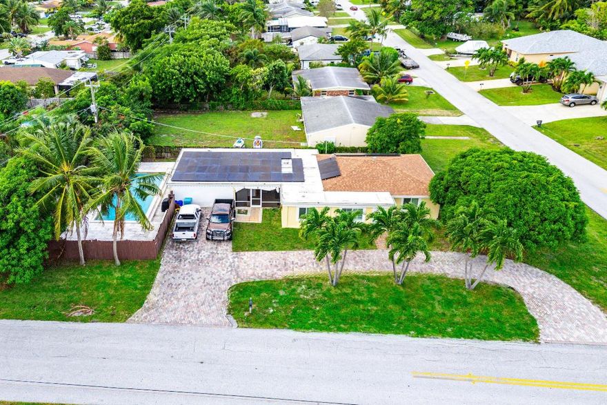 This charming single-family home offers a spacious layout with 4 bedrooms & 3 bathrooms. There are 2 bonus rooms, one used as a 4th bedroom & Office. The home has an open-concept kitchen with granite countertops perfect for entertaining.  Newer appliances from 2017 & 2020. Water heater replaced in 2018. Dive into your private pool on this expansive corner lot offering plenty of room for pets & a boat/trailer. With upgrades such as 2019 hurricane impact windows & doors, 2019 roof, 2019 flat roof, 2019 gutters and downspouts, newer 2020 pool pump, 2021 energy-saving solar panels (cost $60k), 2020 Hurricane Drapes, 2018 Hurricane clips, this home is both secure and efficient. Huge corner lot ready to plant fruit trees. Buyer can take over assumable loan of $270k at 2.6%
