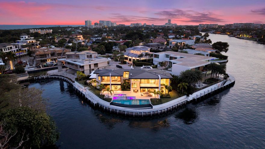 Brand-new Intracoastal estate in Orchid Point offering approximately 230' of waterfront with protected side dockage in a no-wake zone — plus additional dock space on the northwest corner of the property. Positioned on a prime point lot, the residence captures some of the longest Intracoastal views in Boca Raton.
A collaboration by Jag Development, In-Site Design Group and Farache Bromberg Design Studio, the home blends modern architecture with warm organic finishes. Floor-to-ceiling window walls, bleached oak flooring, custom millwork and designer lighting enhance the open, light-filled interiors. A fully integrated smart-home system controls lighting, climate, security and entertainment. The main level includes spacious living and family areas, a club/media room, dedicated bar, and downstairs office   creating a layout that is truly an entertainer's dream. A private downstairs suite with its own entrance provides convenient access to the dock and is ideal for captain/crew quarters, guests, or a separate workspace.
The auto plaza includes a 3-car garage plus additional garage space suitable for captain/crew storage, golf cart or specialty vehicles.
Upstairs, the primary suite features sweeping Intracoastal views, two boutique closets, a sitting area, and a spa-style bath with soaking tub overlooking the water. Two additional ensuite bedrooms and an upstairs laundry room complete the second level.
Outdoor living centers around a gorgeous infinity-edge pool overlooking the Intracoastal, sun shelf, covered lanai and summer kitchen. The 80'± concrete dock is tucked away in its own private canal, offering protected mooring, along with a newly constructed 230'± seawall and cap. Built above FEMA elevation with impact glass and modern mechanical systems.
Located minutes to Boca beaches, The Boca Raton and Beach Club. Shown by appointment only. Proof of funds required for all showings.