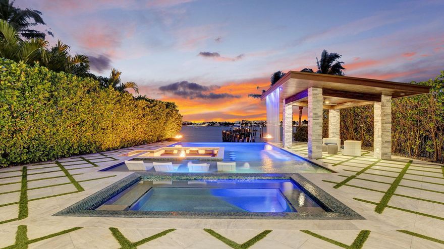 Luxury Waterfront Oasis - An Entertainer's Dream HomeExperience the pinnacle of coastal luxury in this magnificent five-bedroom, five-bathroom estate, perfectly positioned along the Intracoastal Waterway with breathtaking views of the ocean and Palm Beach Island. Designed for those who appreciate impeccable craftsmanship and top-tier amenities, this home offers the ultimate entertainer's paradise.Unrivaled Outdoor LivingInfinity-edge pool & spa overlooking the IntracoastalSunken fire pit with built-in seating for intimate waterfront gatheringsPrivate sandy beach--your own personal waterfront escapeCustom waterfall feature enhancing the tropical ambiancePrivate boat dock with 25,000-lb boat lift, perfect for yacht enthusiasts