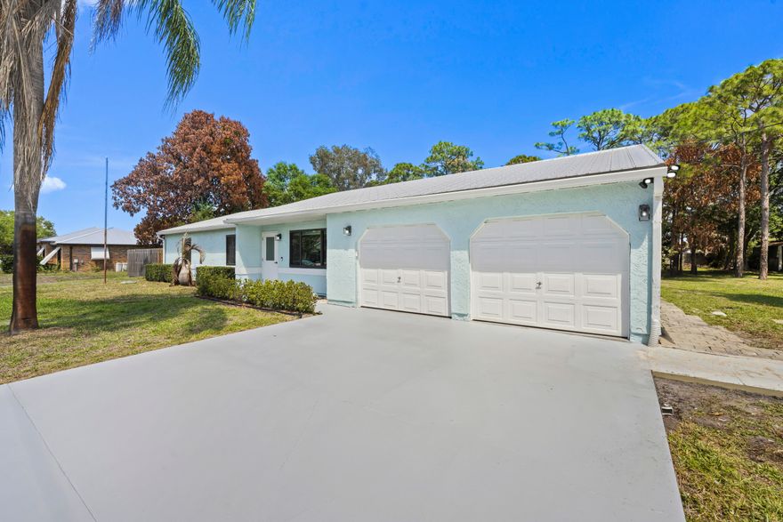 STUNNING COMPLETELY REMODELED home in the heart of Port Saint Lucie! This beautifully upgraded residence features impact windows, metal roof, a/c, city water/sewer, fence , freshly painted driveway, flooring, and high-end luxury finishes throughout, offering a perfect blend of style and comfort. Situated on a spacious half-acre lot, the property offers a private backyard oasis complete with a sparkling pool and relaxing hot tub—ideal for entertaining or unwinding. You'll find an endless list of modern updates, an open and inviting layout, and plenty of outdoor space.  This home is truly move-in ready and ready for a quick close! Perfect as a primary residence, second home, or a lucrative short-term rental investment opportunity—this is a rare find! Close to beaches, shopping and medical!  Metal Roof 2020 , A&G Salt Water Pool 2017, recent Hot Water Tank, Fence 2022, Impact Windows and Doors 2022, City Sewer  hookup 2026.