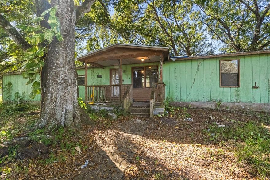 **AGGRESSIVELY & STRATEGICALLY PRICED!!**  5 ACRES of HIGH and DRY land! The home needs some TLC, but the land & existing structures create an incredible opportunity for the next owner with vision. Rural Residential Zoning, you can keep Horses and Livestock and add additional residences, creating room for a true enclave. NEWER AC and TWO spacious SHEDS, each with electric and plumbing, are ideal for equipment storage or can be transformed into hobby rooms, art studios, or even detached offices. A Large Master WORKSHOP, fully powered and plumbed, offers a larger hub for projects, creative work, or small business setup. A CITY APPROVED, Professional Grade AUTOMOTIVE LIFT will be removed prior to closing; However, the existing electrical hookups & structural setup will remain.