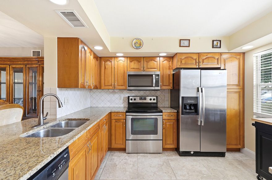 BEST LOCATION IN ALL WYNMOOR!. Desirable and Beautiful 2bedroom/2bath ground floor with panoramic golf/lake views from patio. Open kitchen concept with newer cabinets + granite counter tops and stainless steel appliances. Newer kitchen ceiling. Ceramic floors through-out. A/C (2016). Brand new 2026 electrical panel. Furniture available if Buyers want it. Enclosed patio with jalousie windows and back door. Walk in distance to the  parking space and to the satellite pool. A must see!.