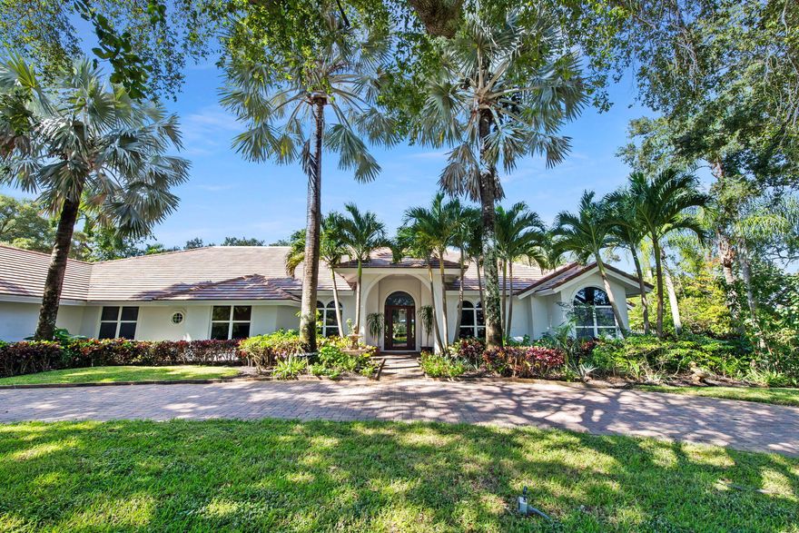 Welcome to this breathtaking 5-bedroom, 3.5-bath estate in the exclusive, guard-gated community of Fieldbrook Estates in the heart of Boca Raton. Situated on a full 1-acre lot of lush, tropical landscaping, this home offers the ultimate blend of privacy, elegance, and South Florida living. Flooded with natural light, the bright, modern interior showcases gorgeous updates and luxurious finishes at every turn. The expansive primary suite is a true retreat — a huge bedroom paired with a stunning, spa-like bath designed for ultimate relaxation. A sleek wet bar and a gorgeous gourmet kitchen with high-end appliances elevate the home's everyday comfort and entertainment appeal. Impact windows and doors throughout provide peace of mind and efficiency. The backyard is a resort-inspired paradise. Retractable screens separate a portion of the outdoor space, while beyond them awaits the rest of the incredible yard. Enjoy a sparkling pool and hot tub, a charming gazebo surrounded by lush gardens and colorful flowers, and a separate fire pit area perfect for relaxing under the stars. At night, the entire yard is illuminated with vibrant, color-changing lighting, creating a magical ambiance. With a massive driveway and spectacular indoor-outdoor amenities, this home truly embodies luxurious Boca Raton living - a rare opportunity in one of the area's most prestigious neighborhoods.