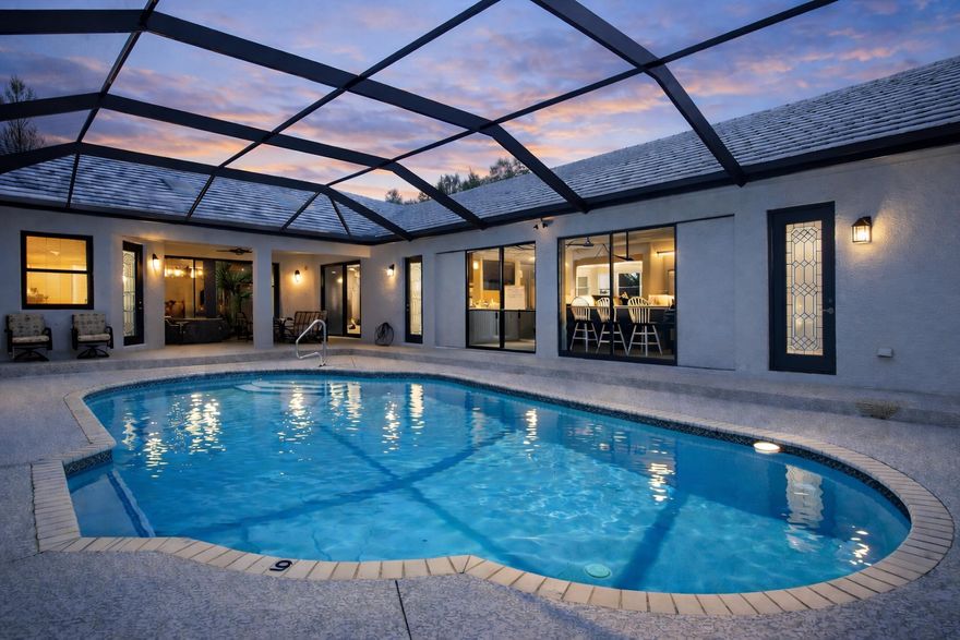 Looking for space for everyone? This renovated CBS multi-gen home features 5 bedrooms & 3 baths in main home PLUS an attached guest house with full kitchen + 2 bedrooms.  Located on 3 picturesque acres with mature oaks, fenced yard and  a massive 1,824 workshop. For equestrian enthusiasts, there's a 1,444 sq ft 5 stall barn with AC tack room & all new fencing with 3 paddocks in this premier guarded gated Equestrian community centrally located by I95 in Palm City and only 50 minutes to Wellington, the winter equestrian capital.  Enjoy family time on the 1,000 sq of covered porches, in the outdoor kitchen that opens onto the enclosed pool area, or in the game room, family room, living room, or in the school office. Upgrades include all new flooring, new kitchen with stone quartzite counters, newly painted inside and out, all remodeled bathrooms, new pool enclosure, pool heater and pump, and new water heaters. There is a 25 acre vacant lot adjacent to the property as for sale.  Combine this house with that lot for a truly remarkable equestrian property with trails and space for all of your animals.  Golf & social memberships are available for the Cape Club