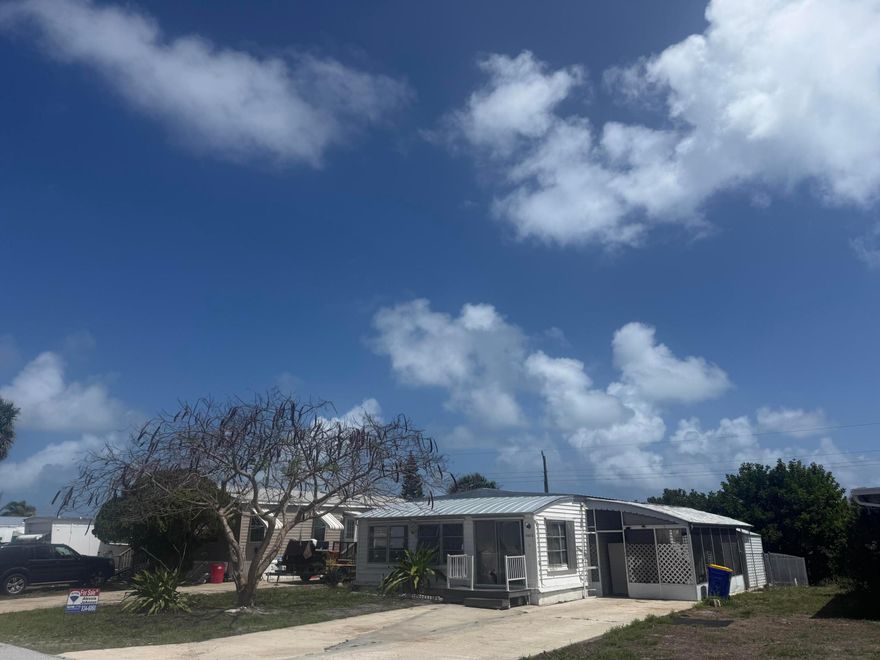 LAND OWNED NO HOA! Handyperson Wanted! Needs total Re-Hab or remove and put a new Manufacture Home or Site built home on the lot! 2BED/2BATHS 960 SQ FT! Front and Side Porches! Metal Roof, Hot Water Heater and Electric panel they were updated from prior owner! Lot Size 50x100 City Water and Septic. Bring your Truck, Boat/Rv, all Ages, Pets!!! Sold As-is Cash Only! If you like to join there is a Clubhouse and Heated Pool for  $365 Year! 2 Mile to Hobe Sound Beach and Downtown Hobe Sound and Shopping! EZ To Show!