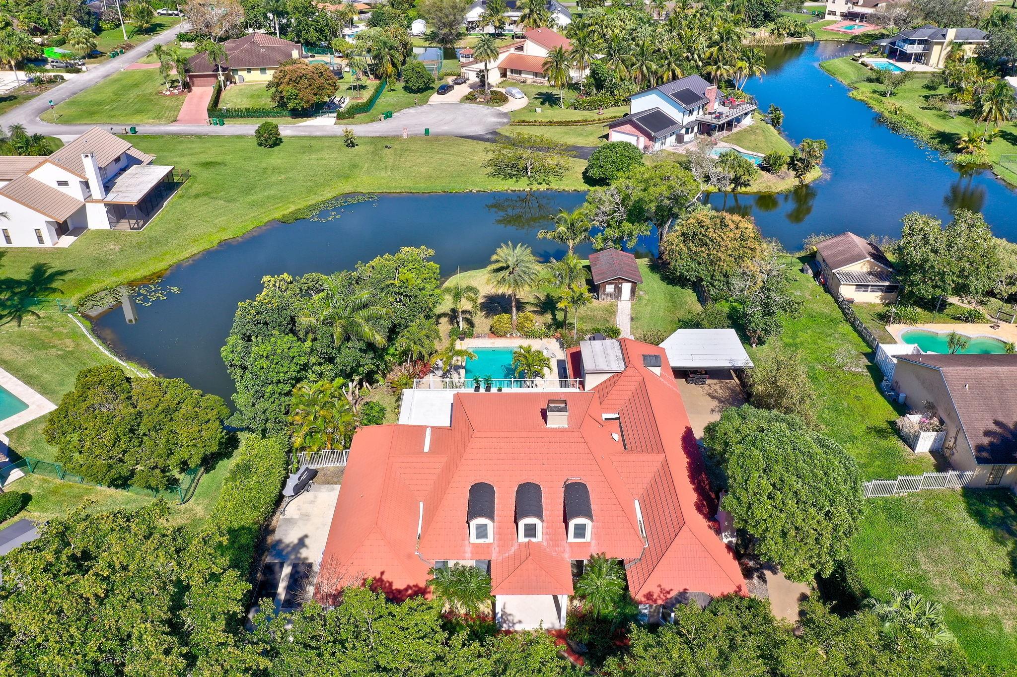 Experience the best of an idyllic private estate in the heart of Davie! This beautifully updated home sits on a sprawling lot, offering peace, privacy, & plenty of space to enjoy the outdoors. With modern upgrades throughout, this home blends rustic charm w/contemporary comfort. The private primary suite takes up the entire second floor with beautiful views of the lake & backyard oasis while 3 additional bedrooms & an office are on the main floor. In addition, you'll find a private hidden bedroom & bathroom above the garage. Nestled in a quiet neighborhood with a true rural feel, yet just minutes from top-rated schools, shopping, & major highways. NO HOA. Bring your animals, RV, or boat—there’s room for it all! A rare opportunity to own a move-in-ready country retreat in a prime location.