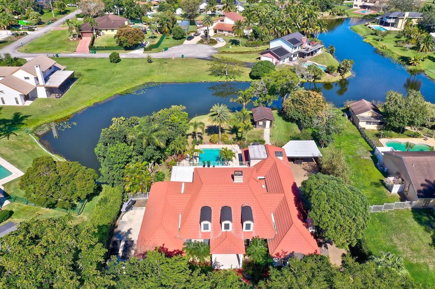 Experience the best of an idyllic private estate in the heart of Davie! This beautifully updated home sits on a sprawling lot, offering peace, privacy, & plenty of space to enjoy the outdoors. With modern upgrades throughout, this home blends rustic charm w/contemporary comfort. The private primary suite takes up the entire second floor with beautiful views of the lake & backyard oasis while 3 additional bedrooms & an office are on the main floor. In addition, you'll find a private hidden bedroom & bathroom above the garage. Nestled in a quiet neighborhood with a true rural feel, yet just minutes from top-rated schools, shopping, & major highways. NO HOA. Bring your animals, RV, or boat—there’s room for it all! A rare opportunity to own a move-in-ready country retreat in a prime location.